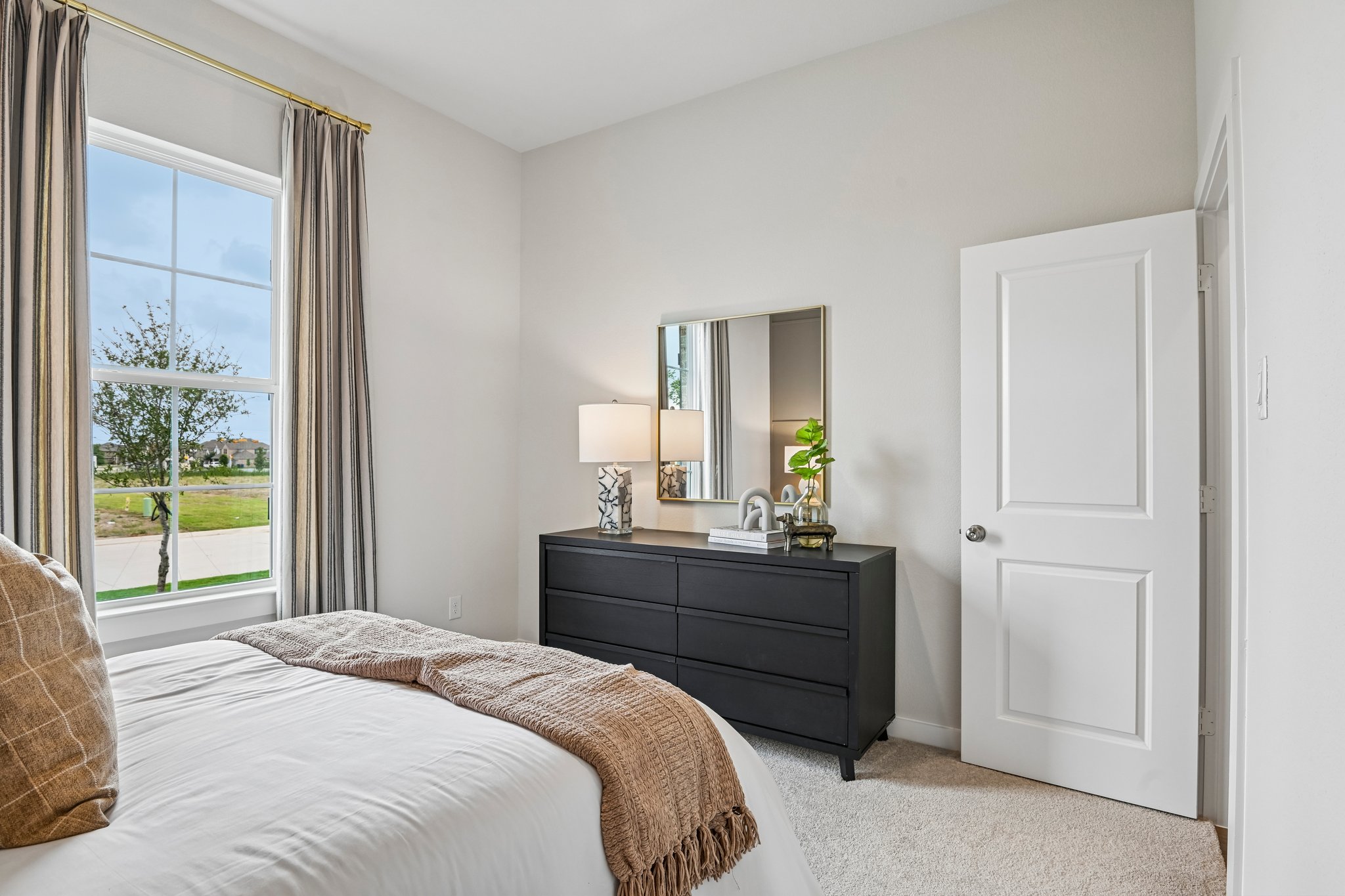 A bedroom with a large window.