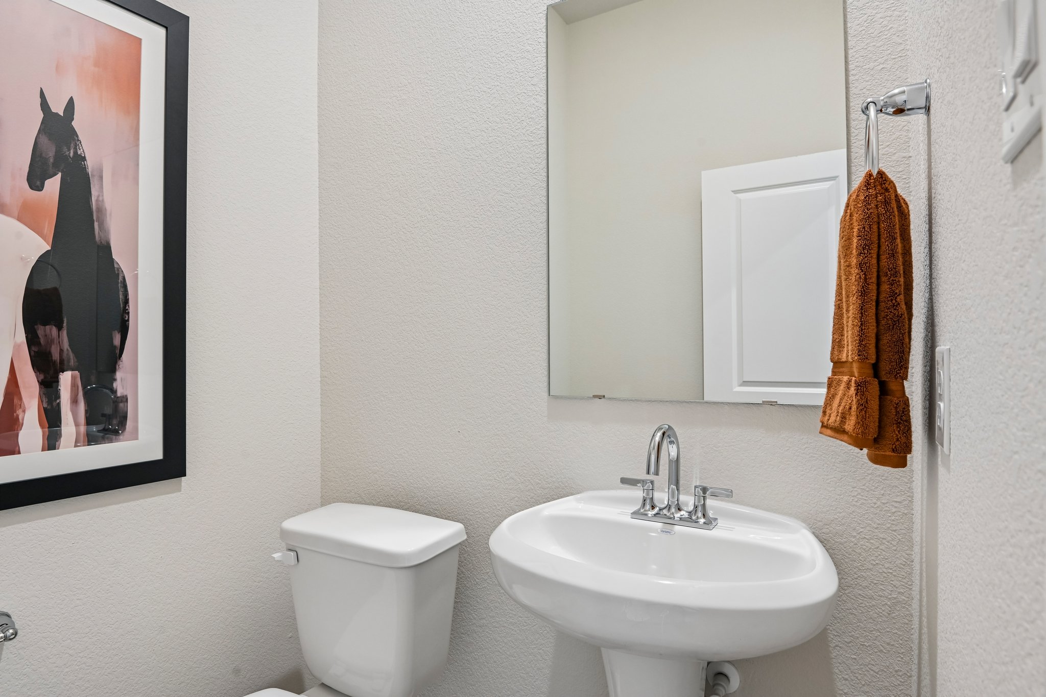 A bathroom with a picture on the wall.