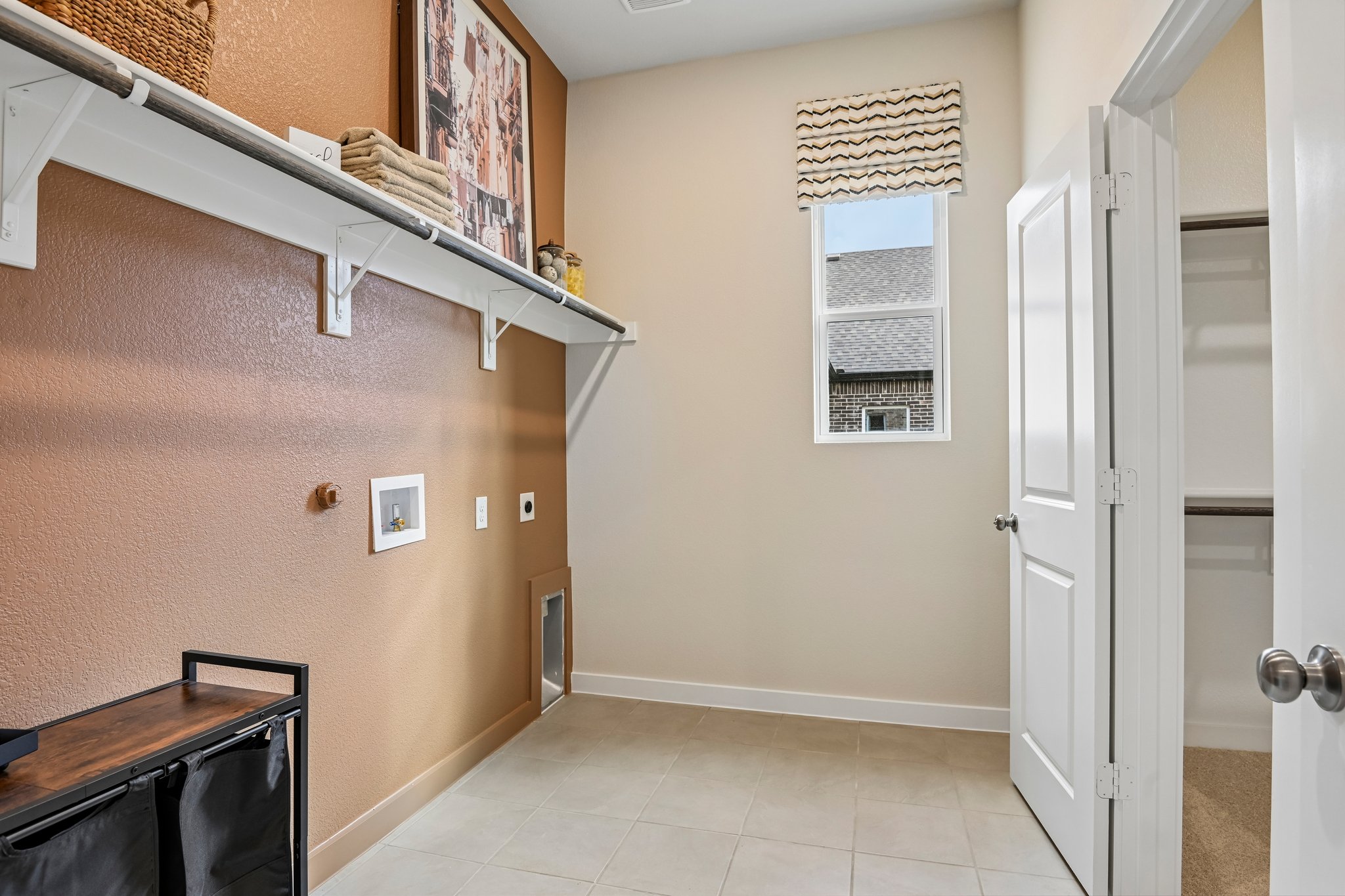 A room with a shelf and a door with a window.