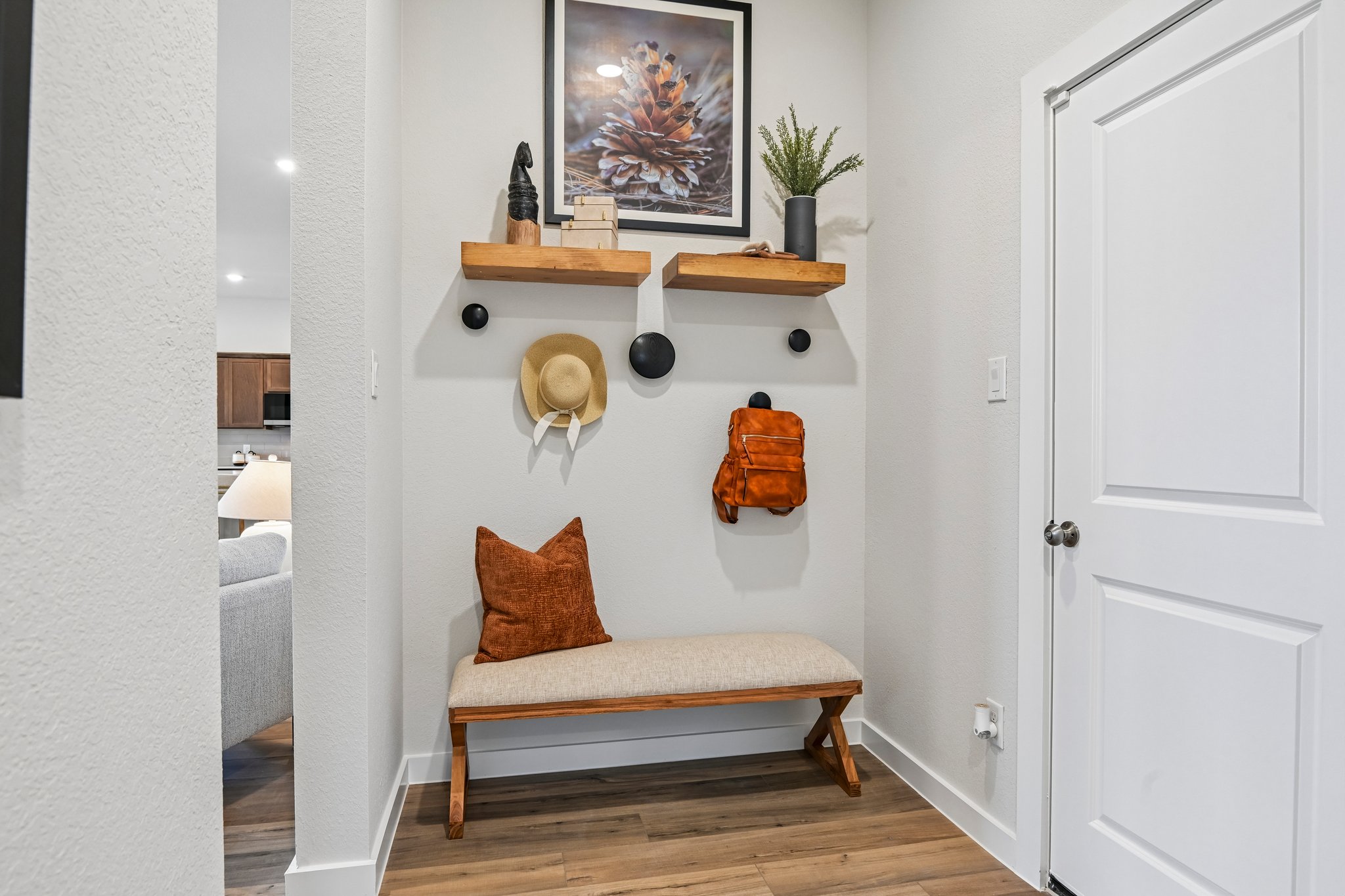 A white room with a shelf and a white door.