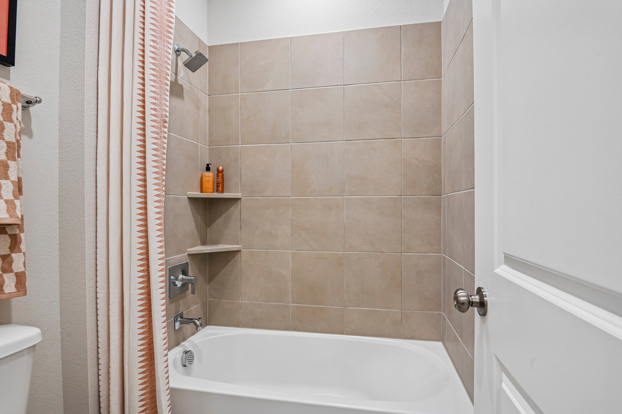 A bathroom with a bathtub and shower curtain.