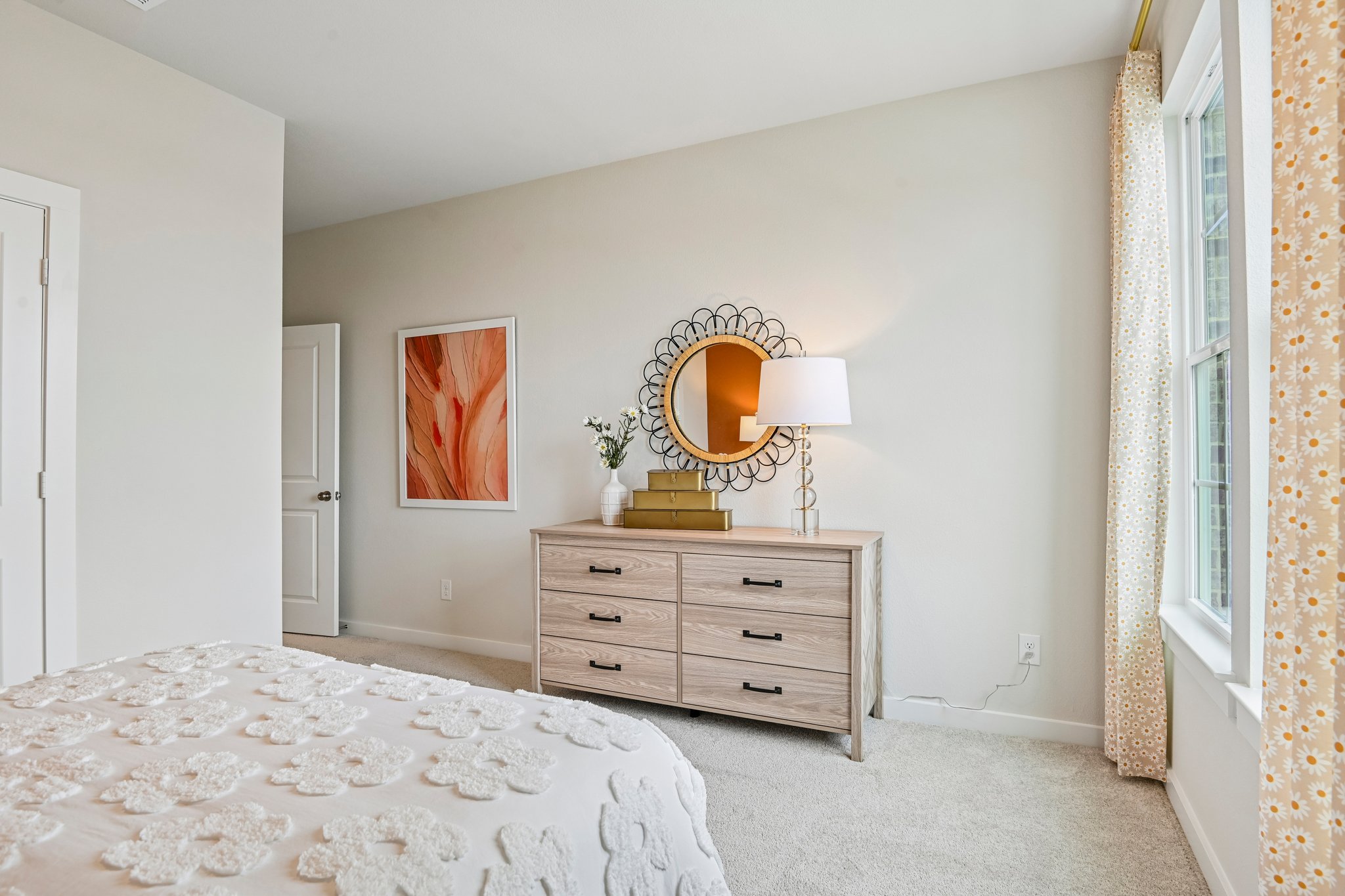 A bedroom with a mirror and dresser.