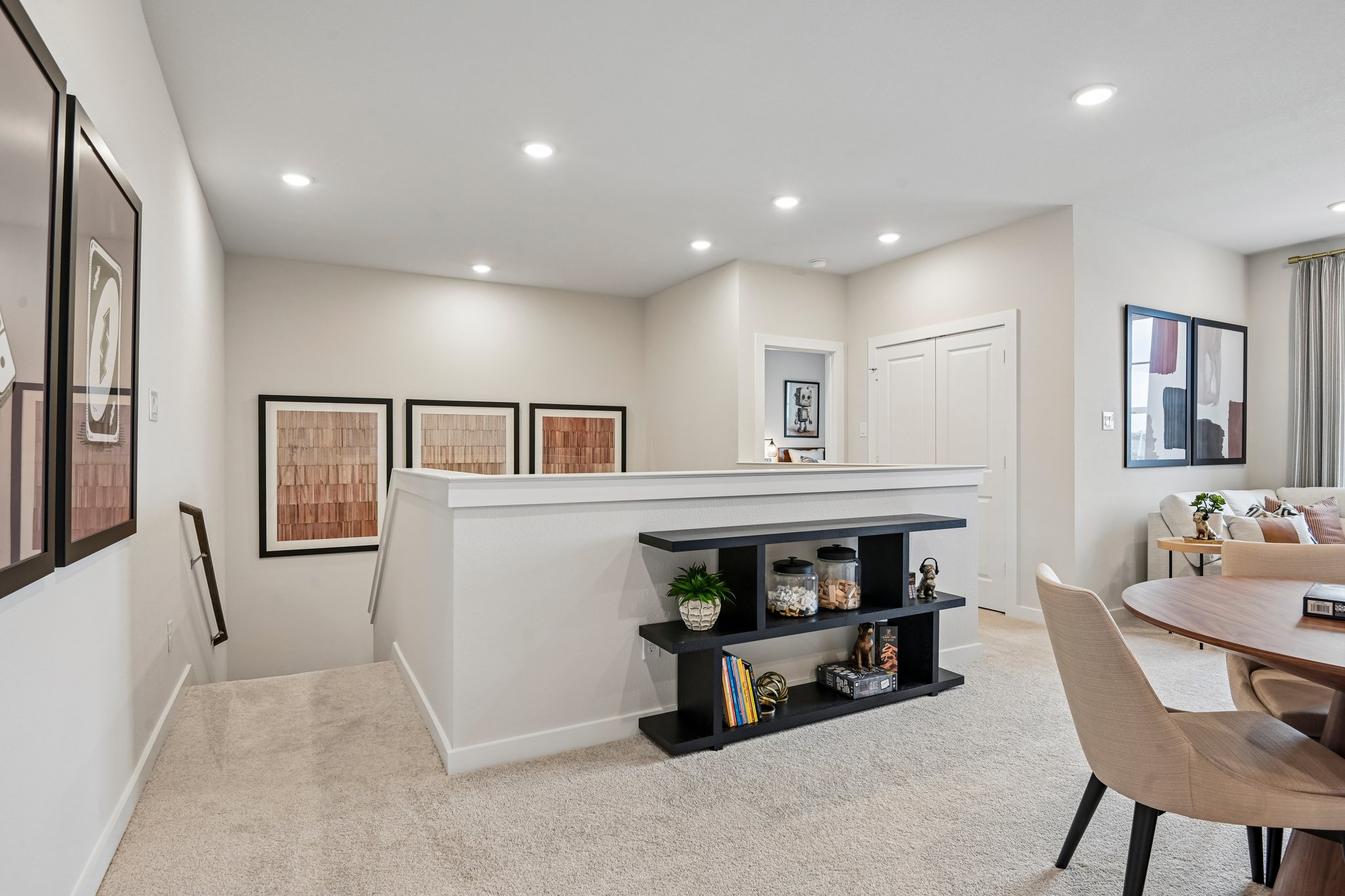 A room with a large white counter and a black table with chairs.