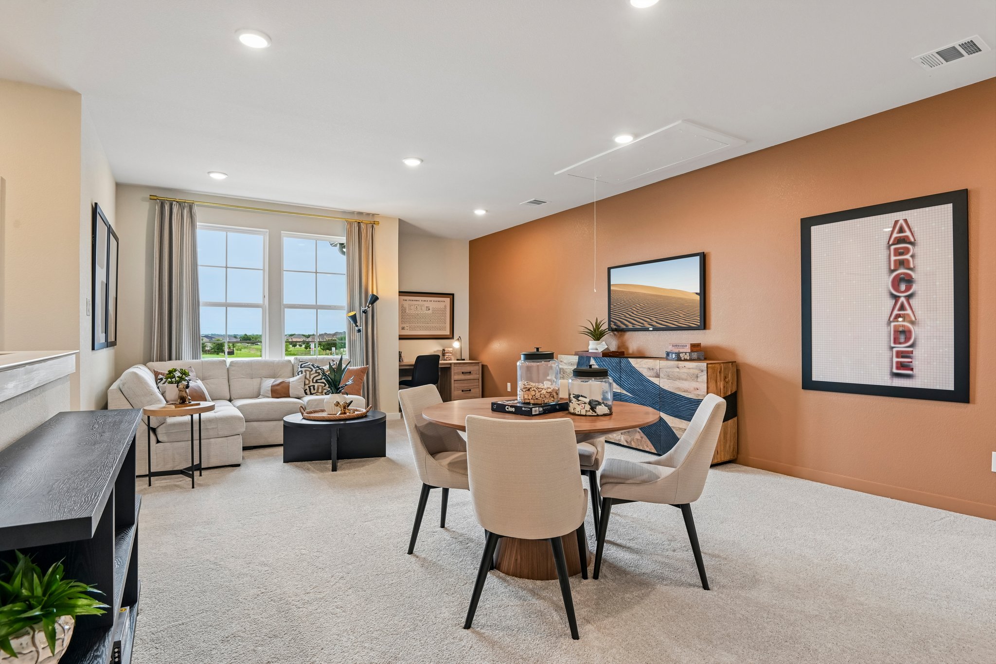 A living room with a large table and chairs.