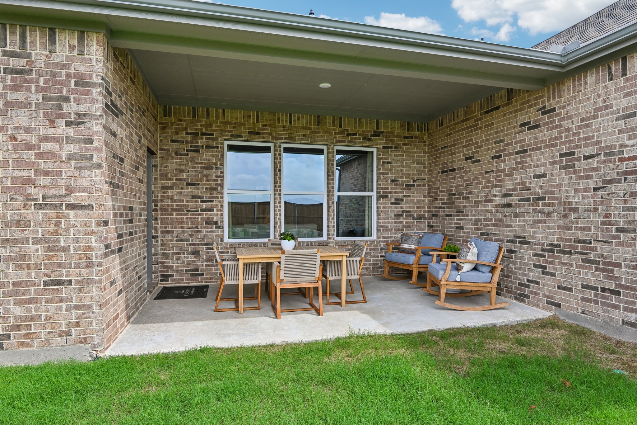 A brick building with a patio and chairs.