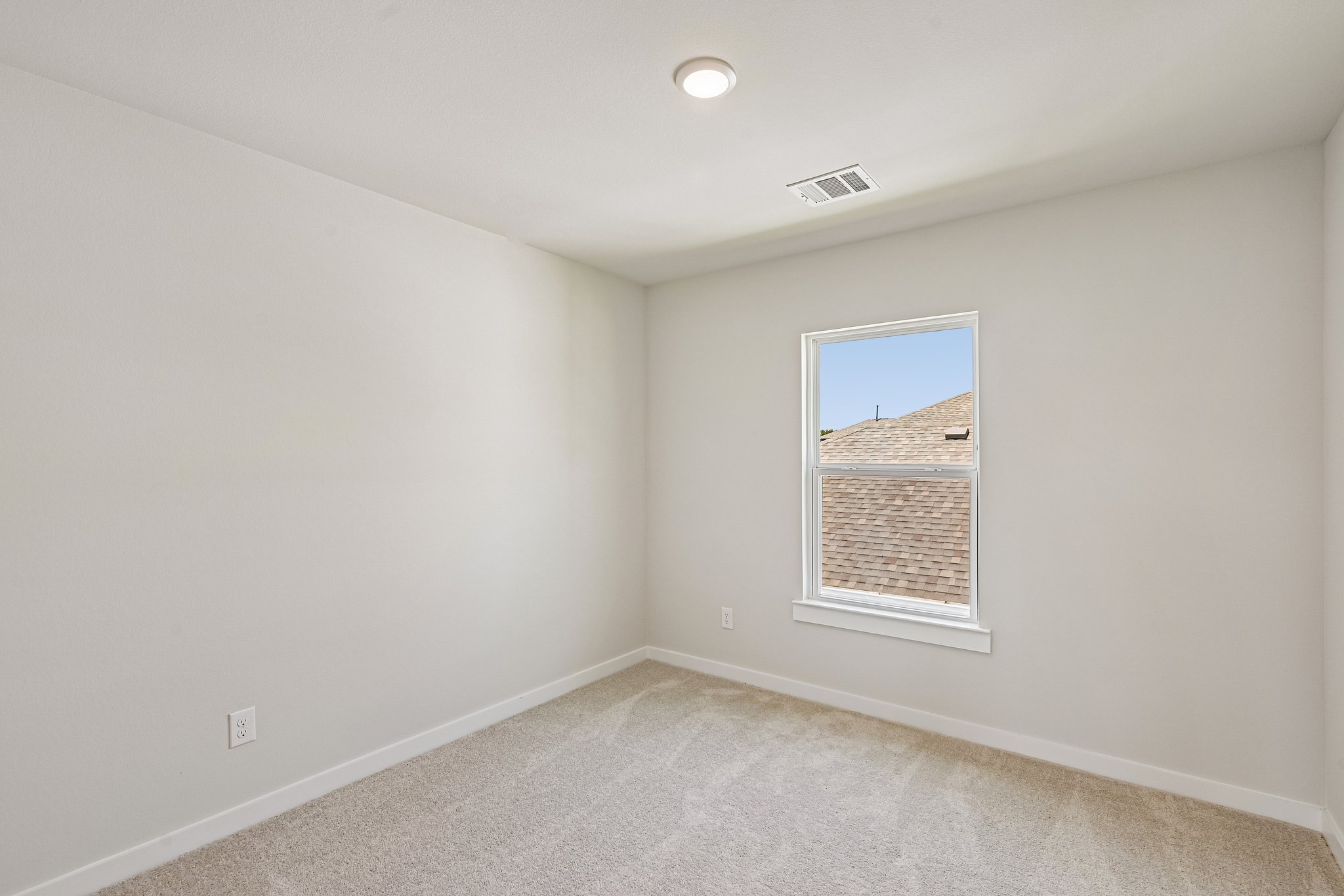 A room with a window and a carpet.