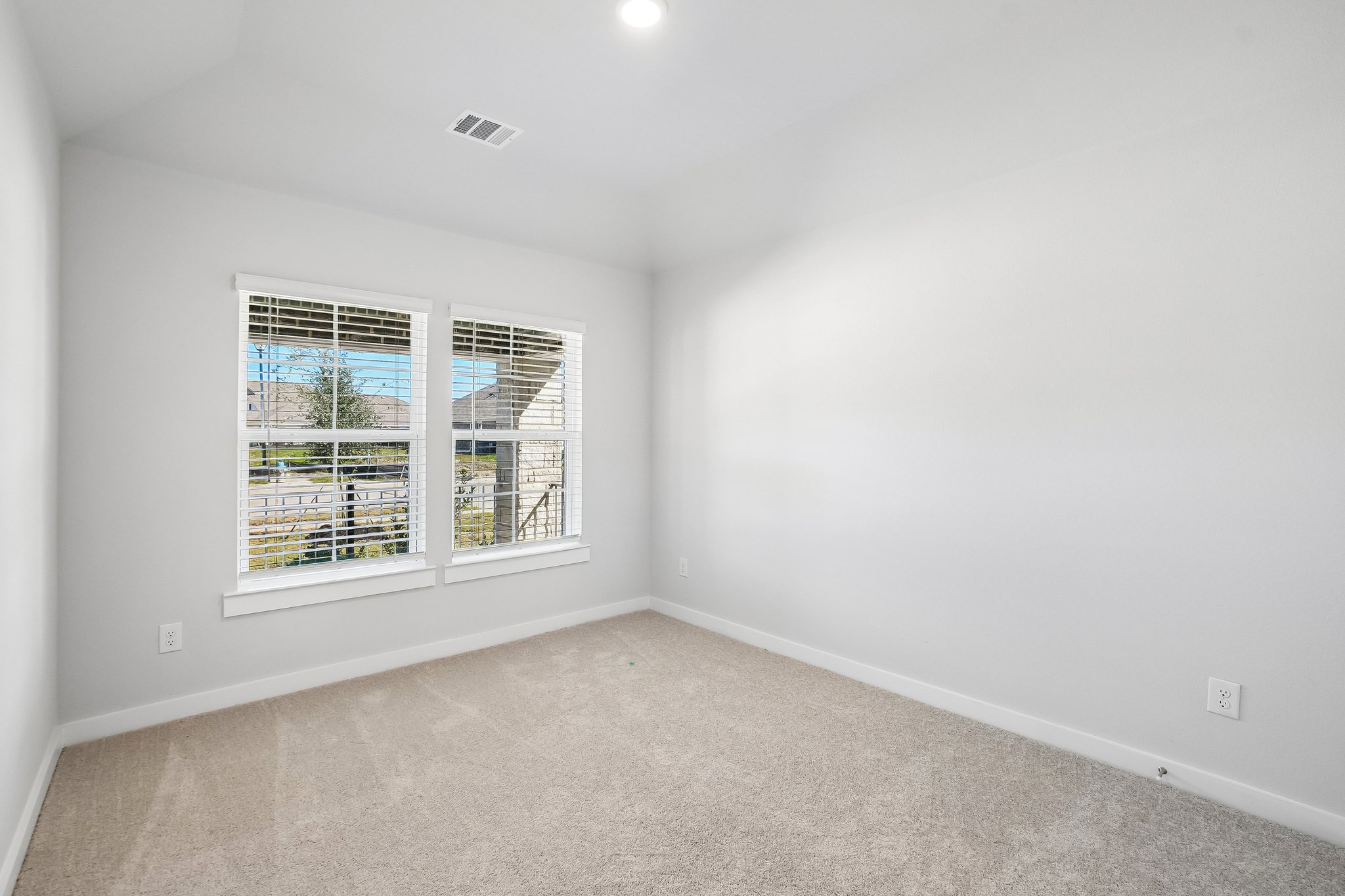 A room with a window and a carpet.