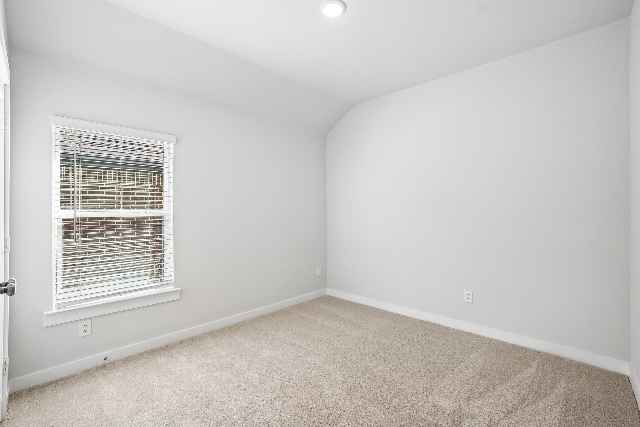 A room with a window and a carpet.