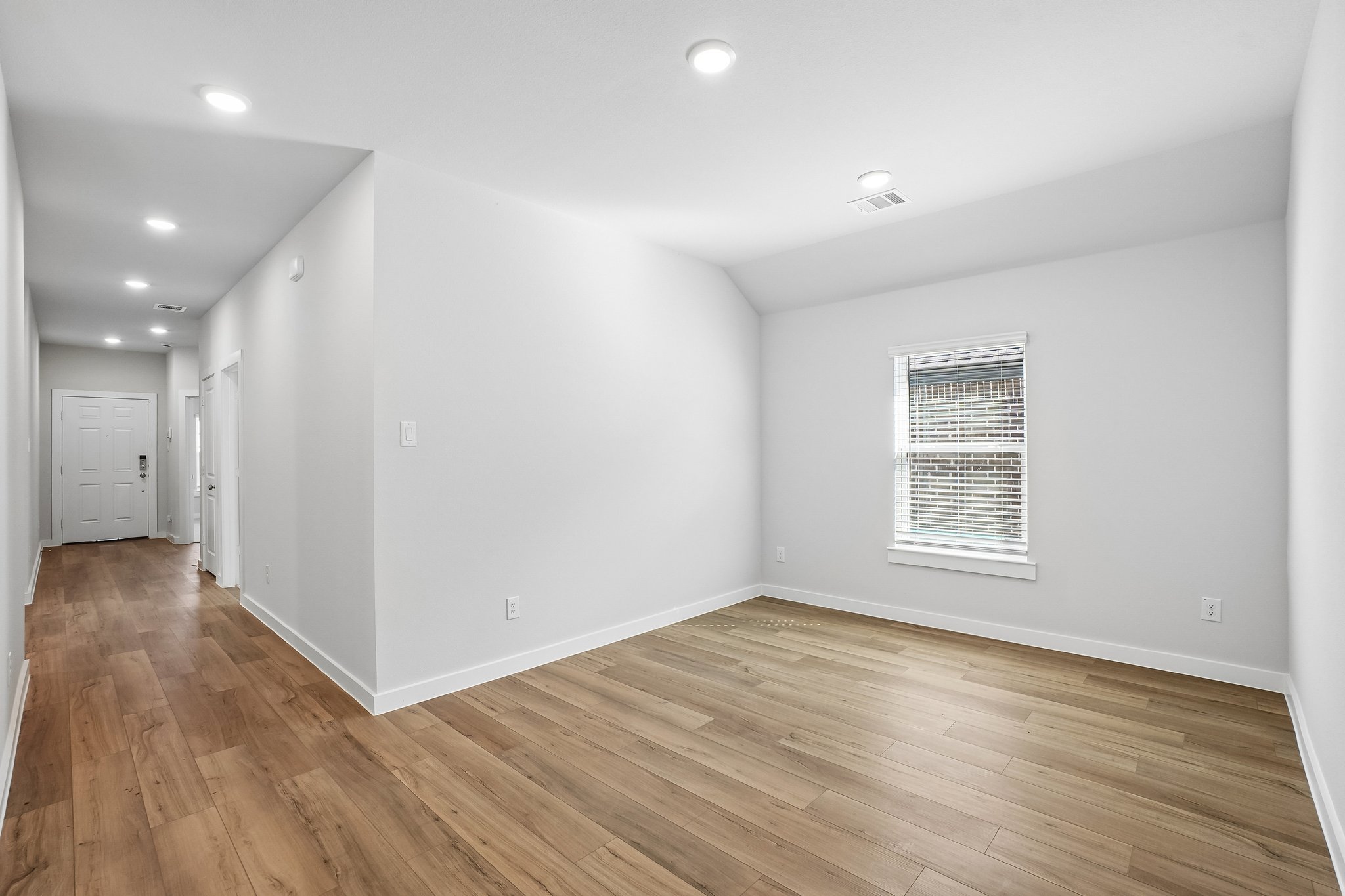 A room with a wood floor and white walls.