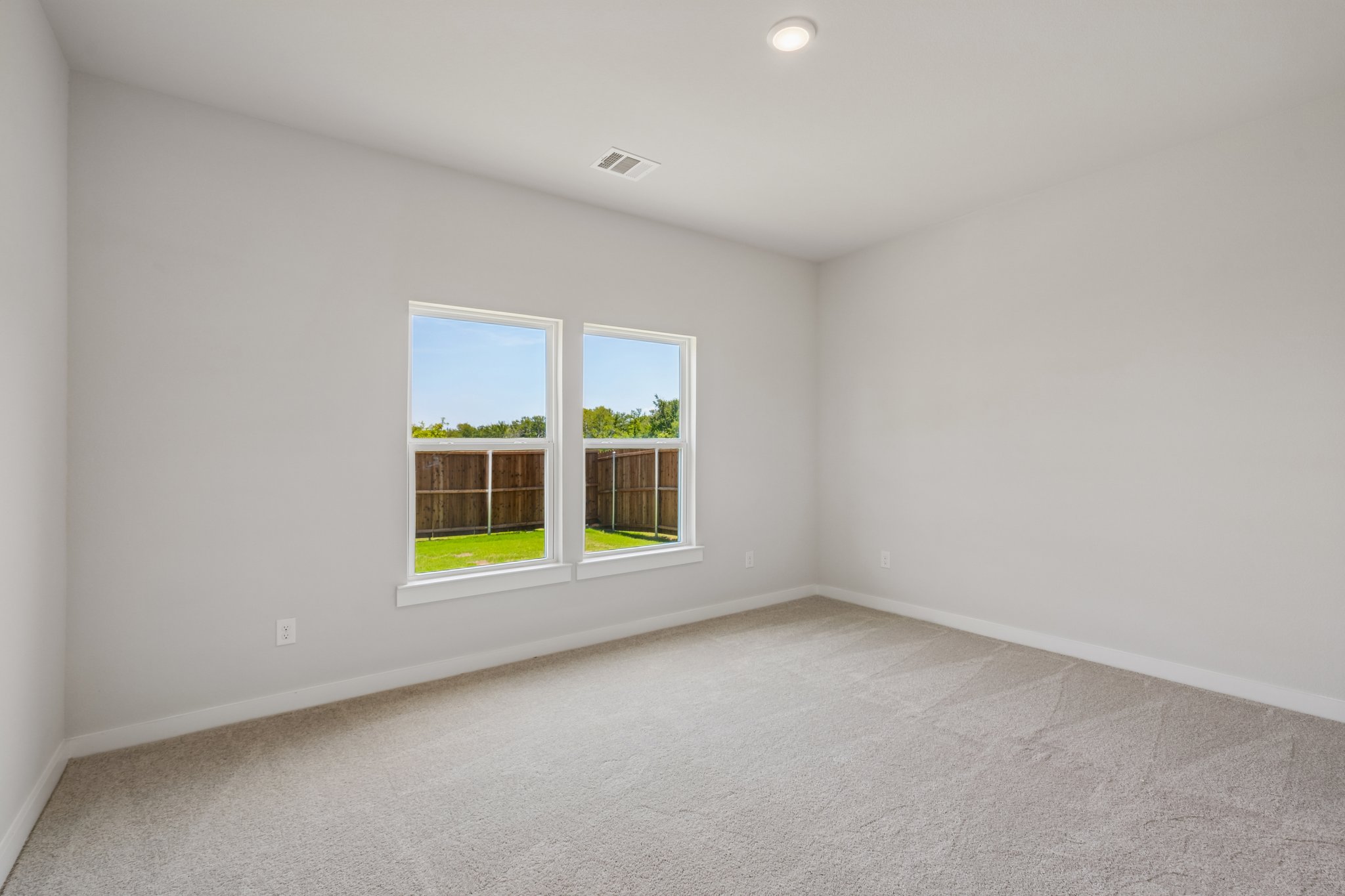 A room with a window and a carpet.
