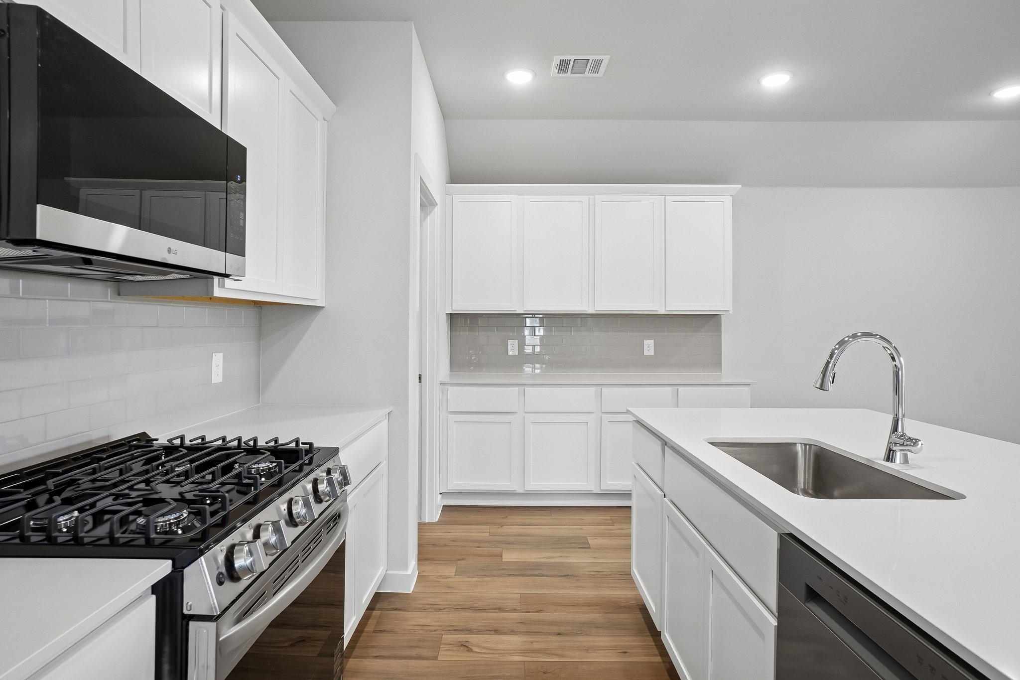 A kitchen with white cabinets.