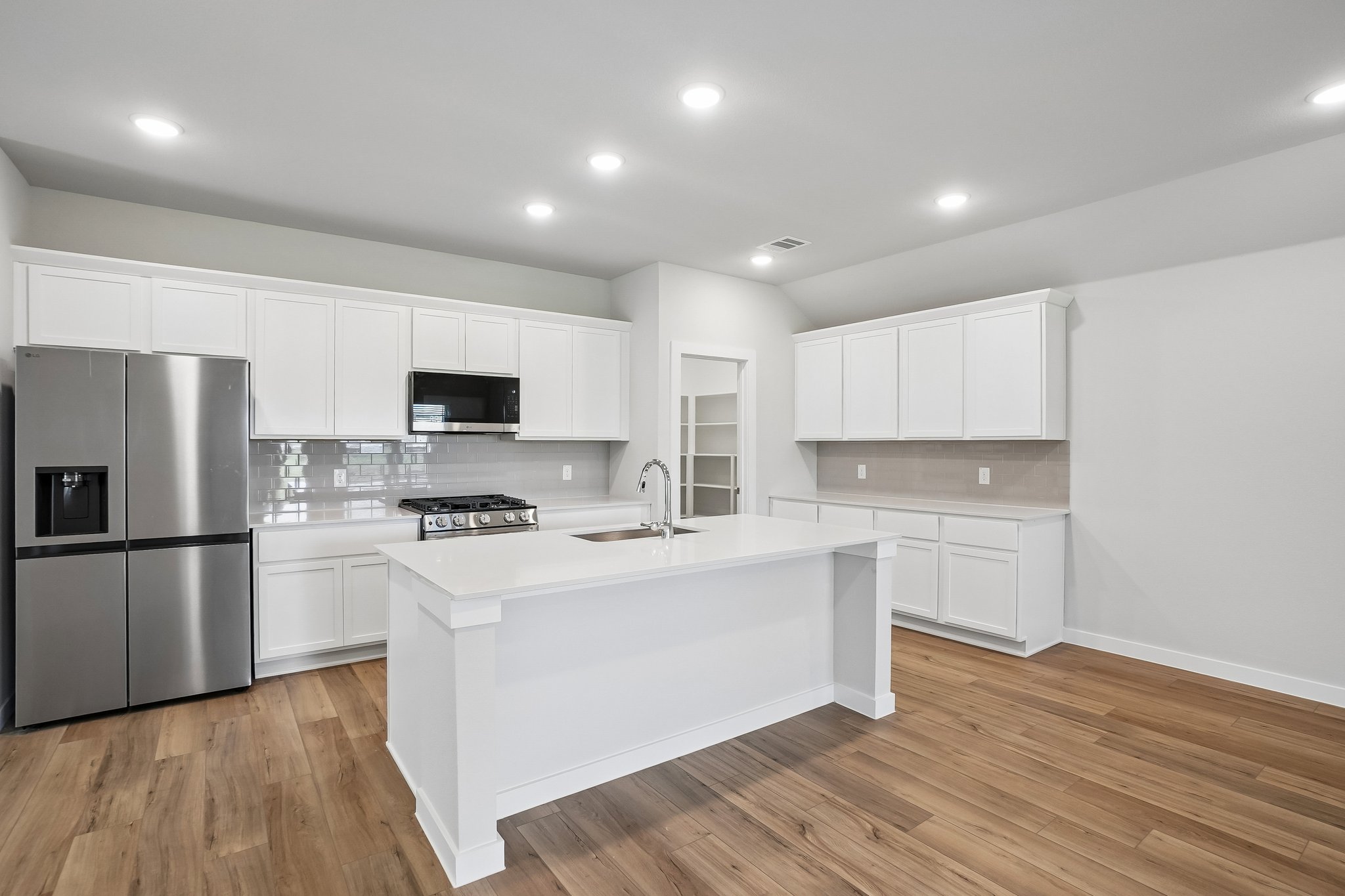 A kitchen with white cabinets.