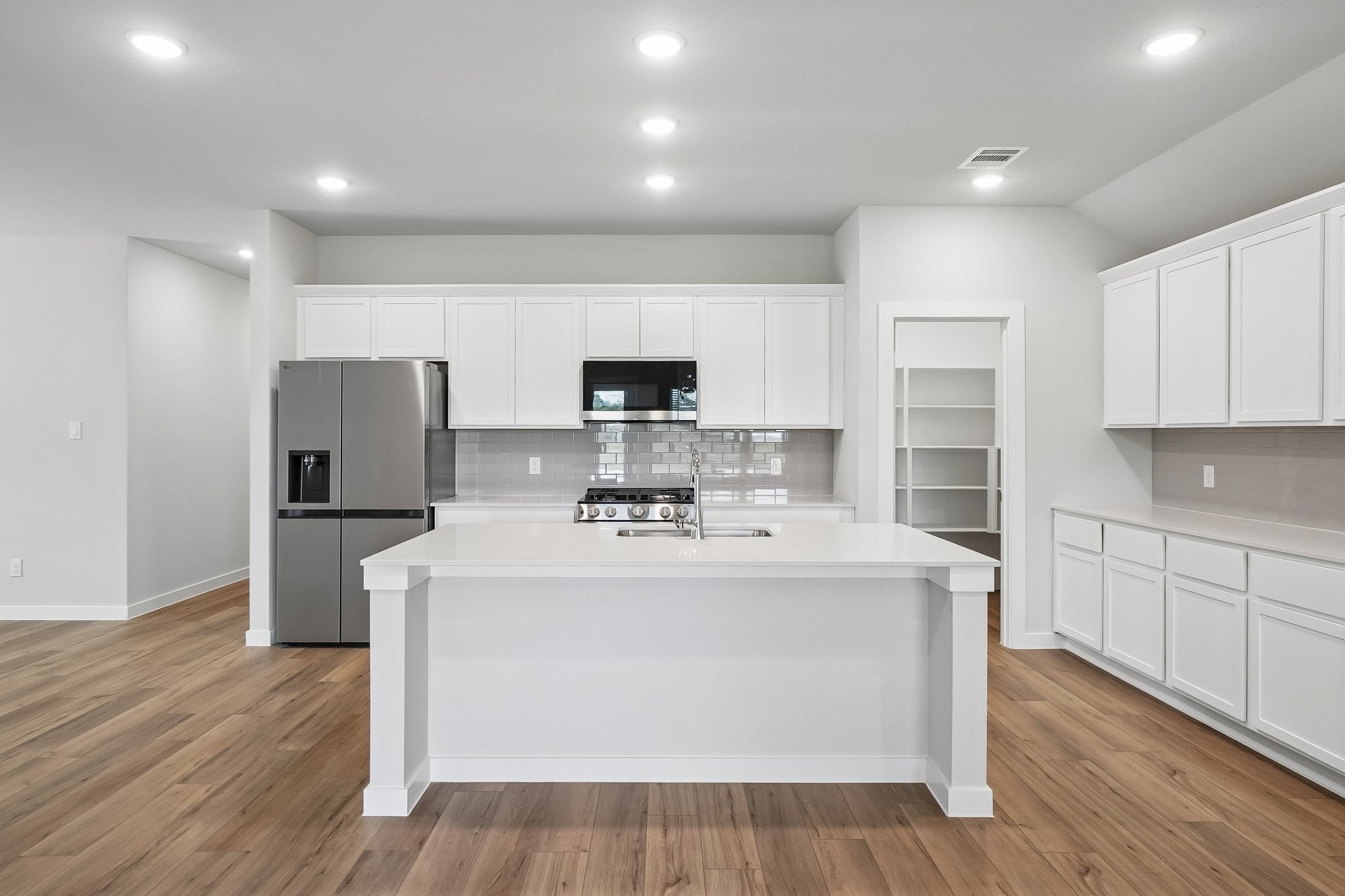 A kitchen with white cabinets.