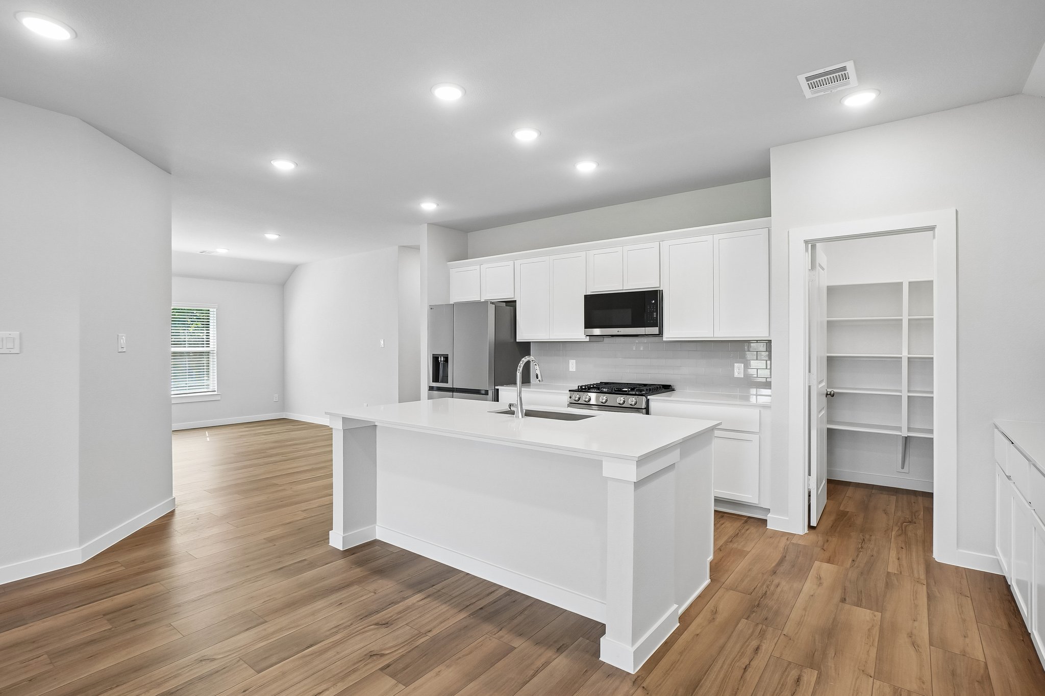A kitchen with white cabinets.