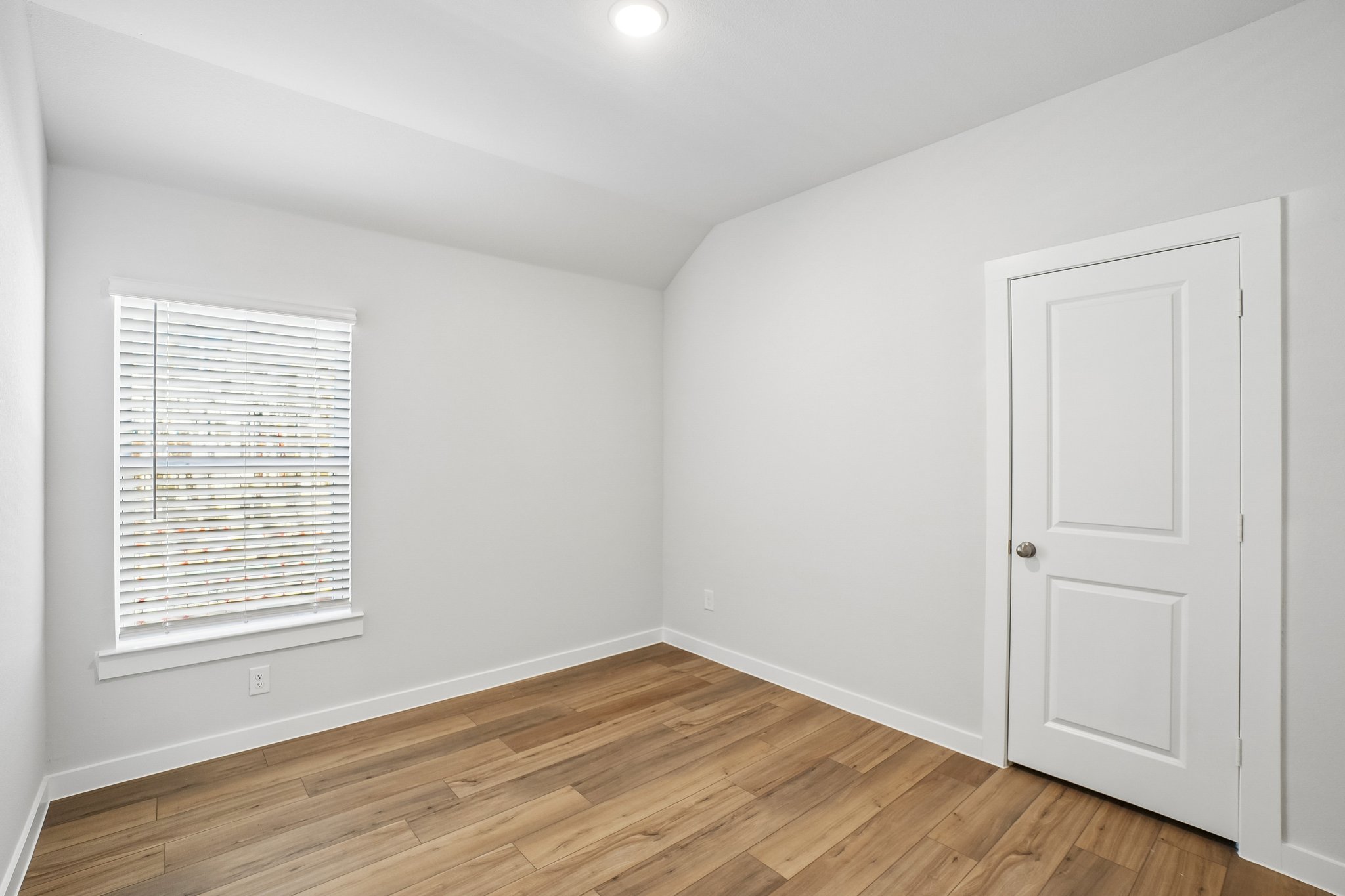 A room with a wood floor and white walls.