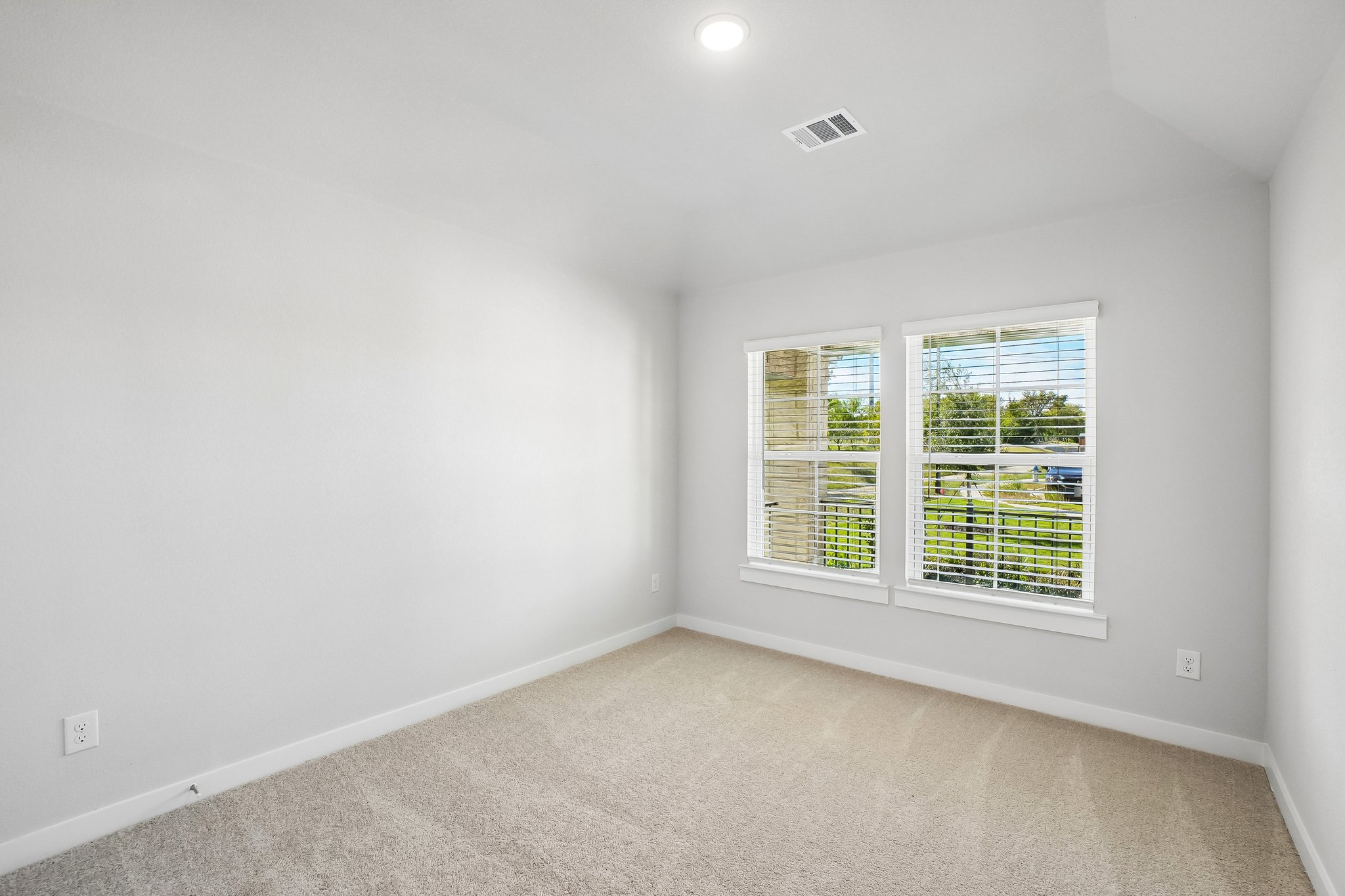 A room with a window and a carpet.