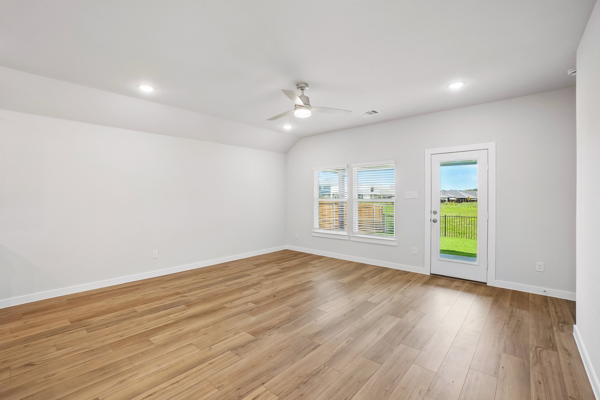 A room with a wood floor and a wood floor with a light on.