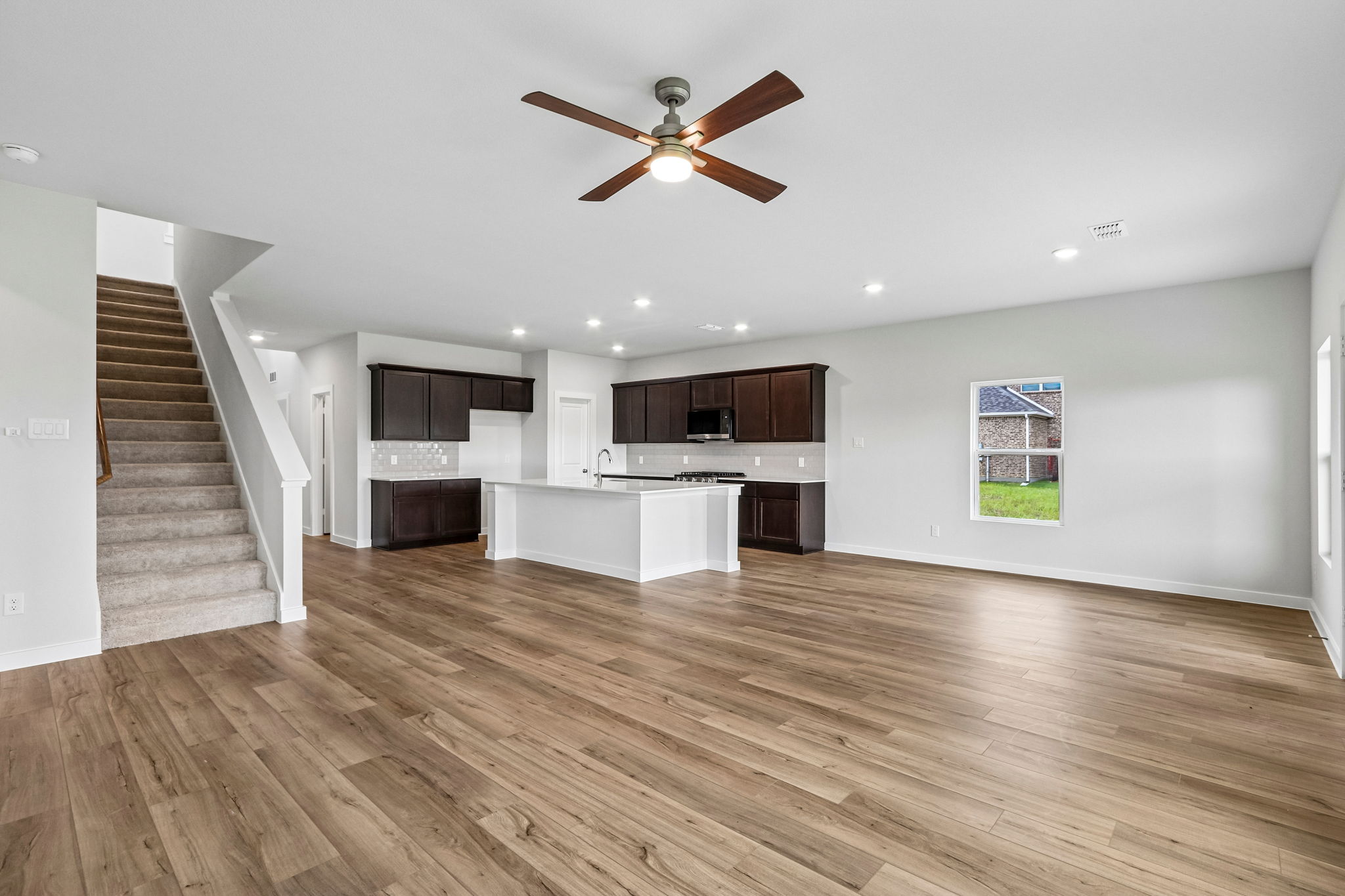A large kitchen with a wood floor.
