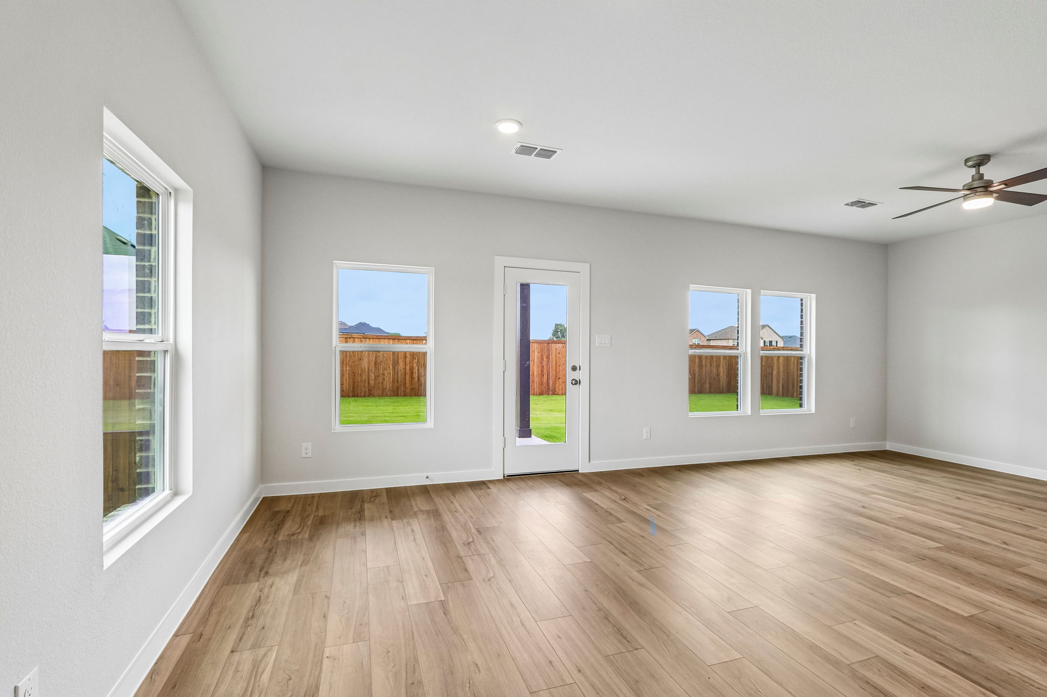 A room with windows and a wood floor.