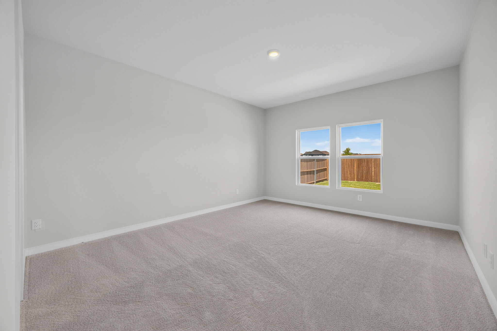 A room with a carpet and windows.