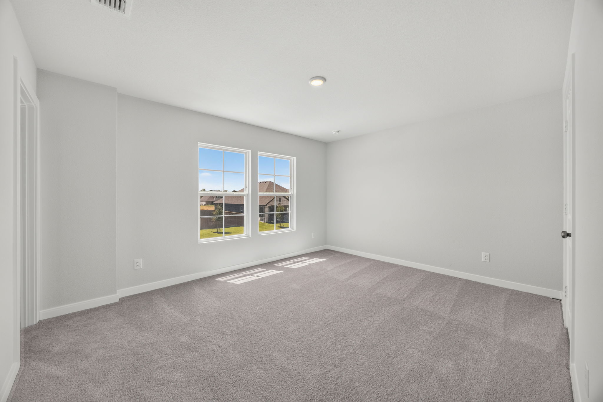 A room with a window and a carpet.