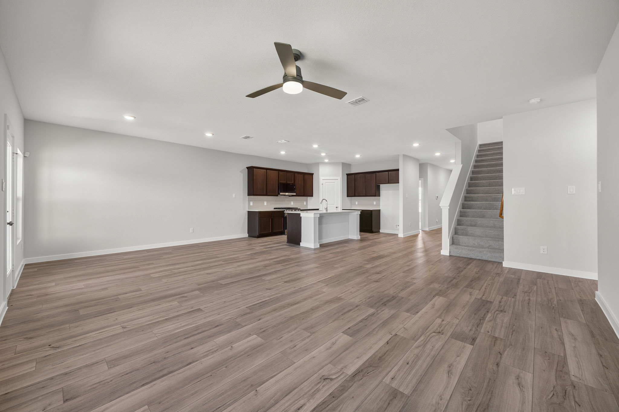 A large empty room with a wood floor and a wood floor.