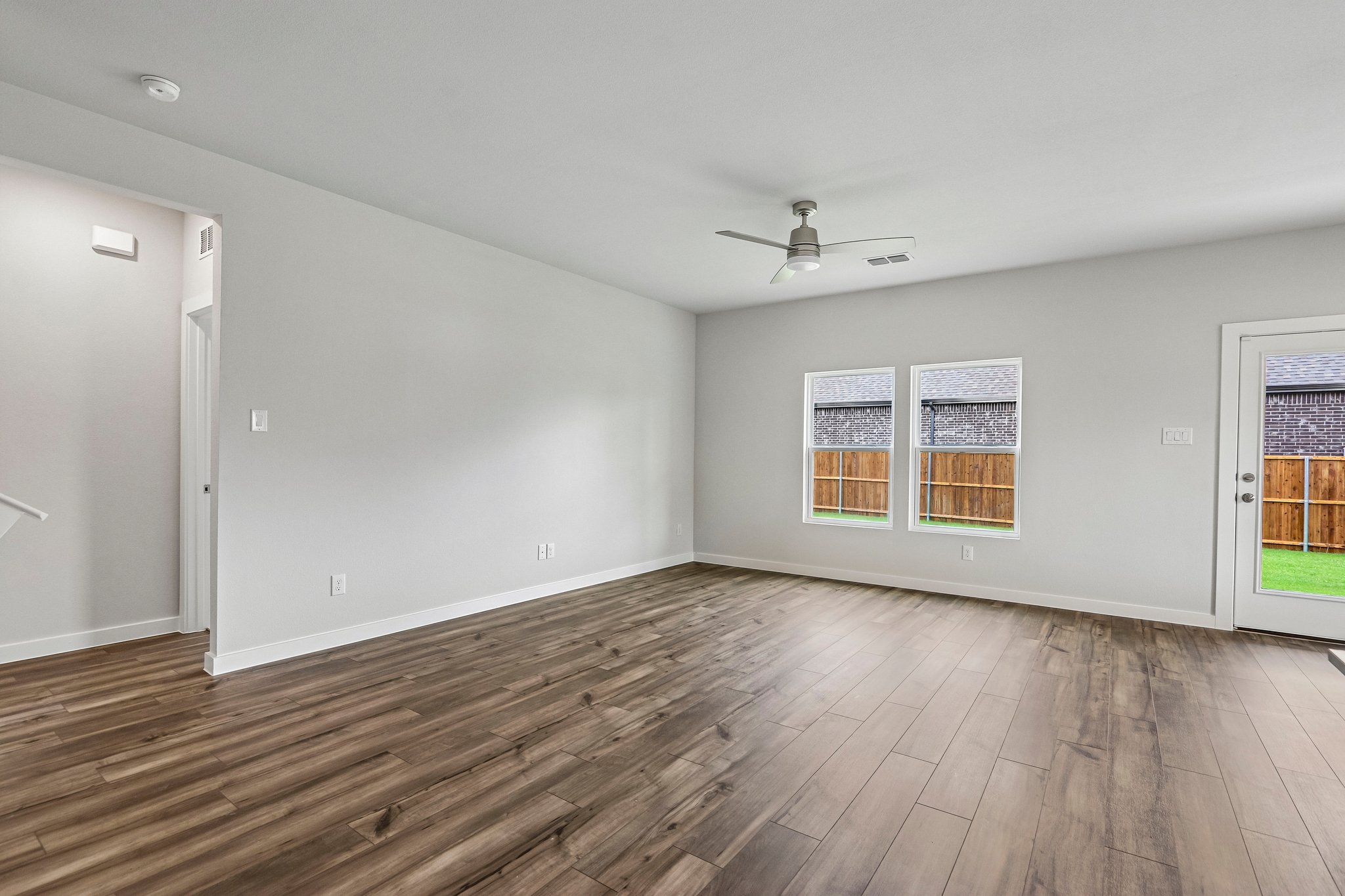 A room with a wood floor and a ceiling fan.
