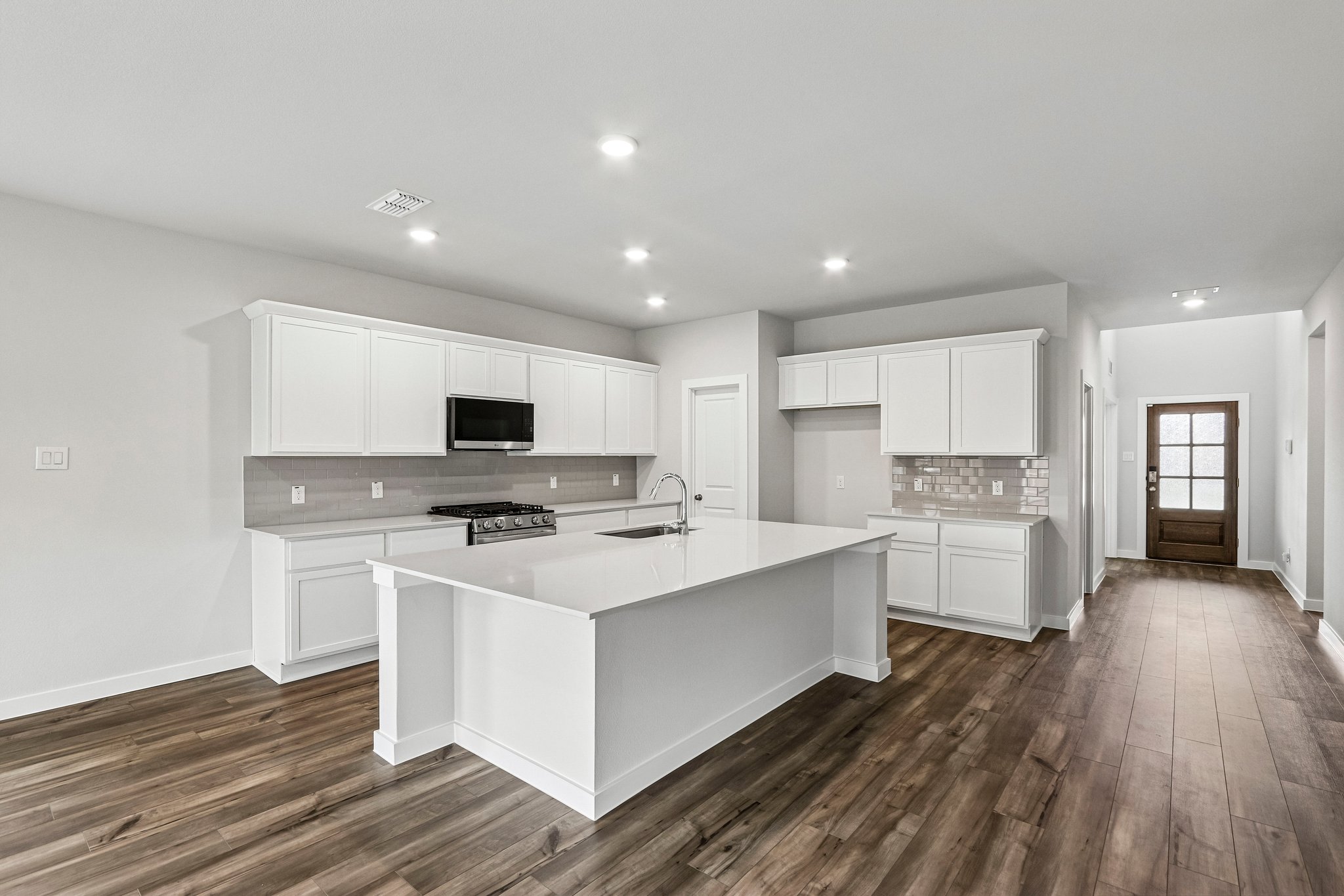 A kitchen with white cabinets.