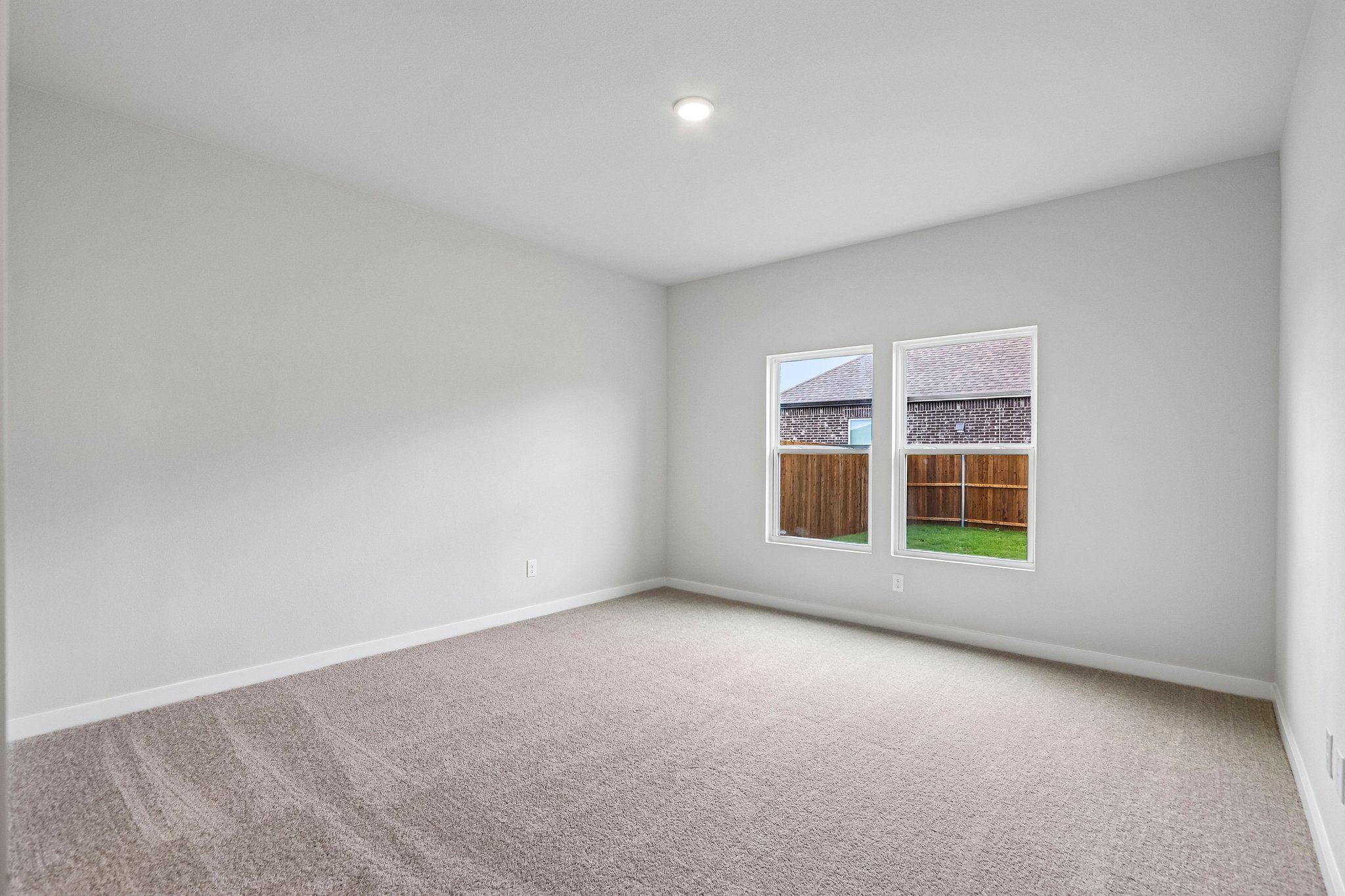 A room with a carpet and a window.