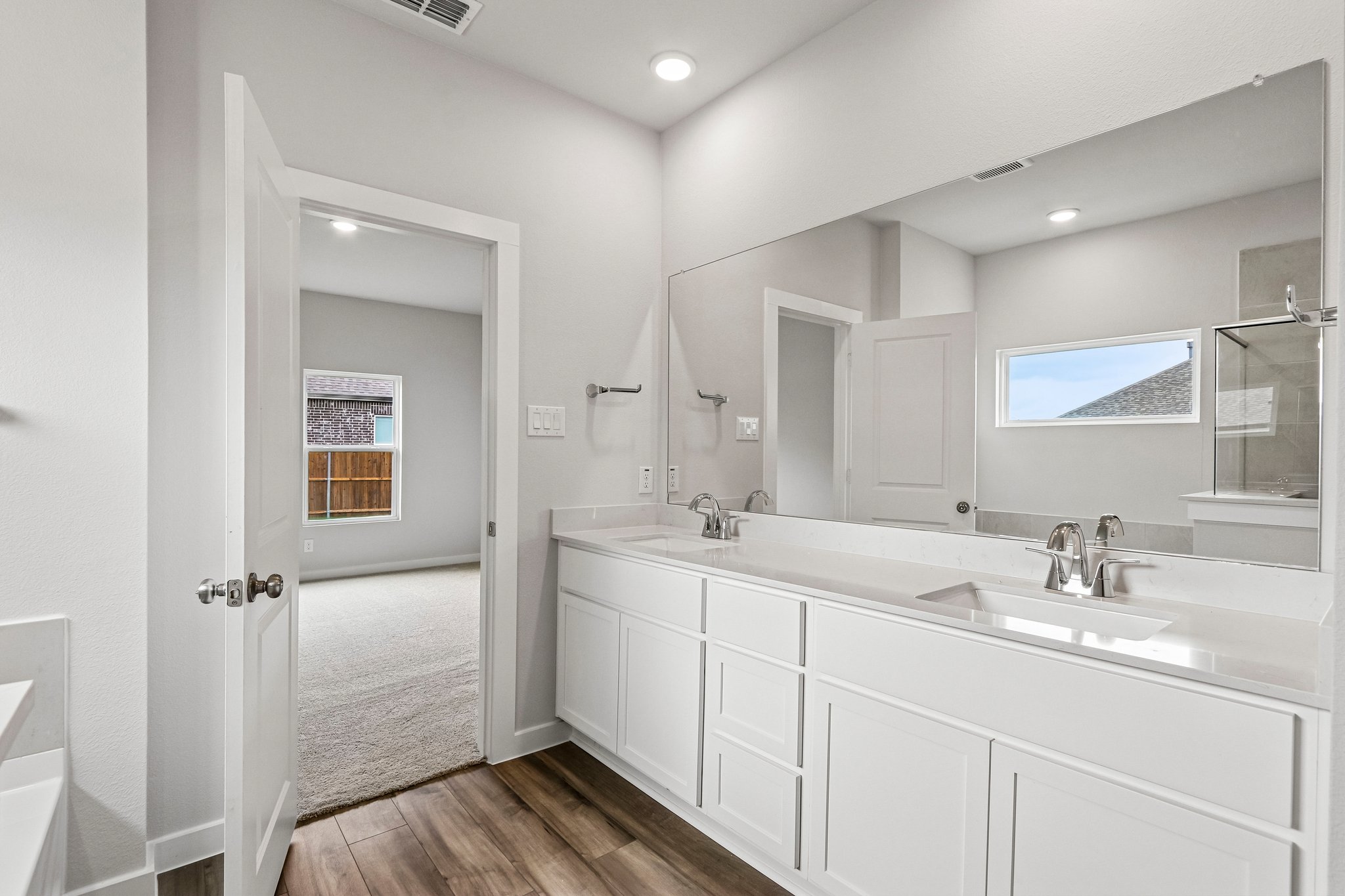 A bathroom with white cabinets.