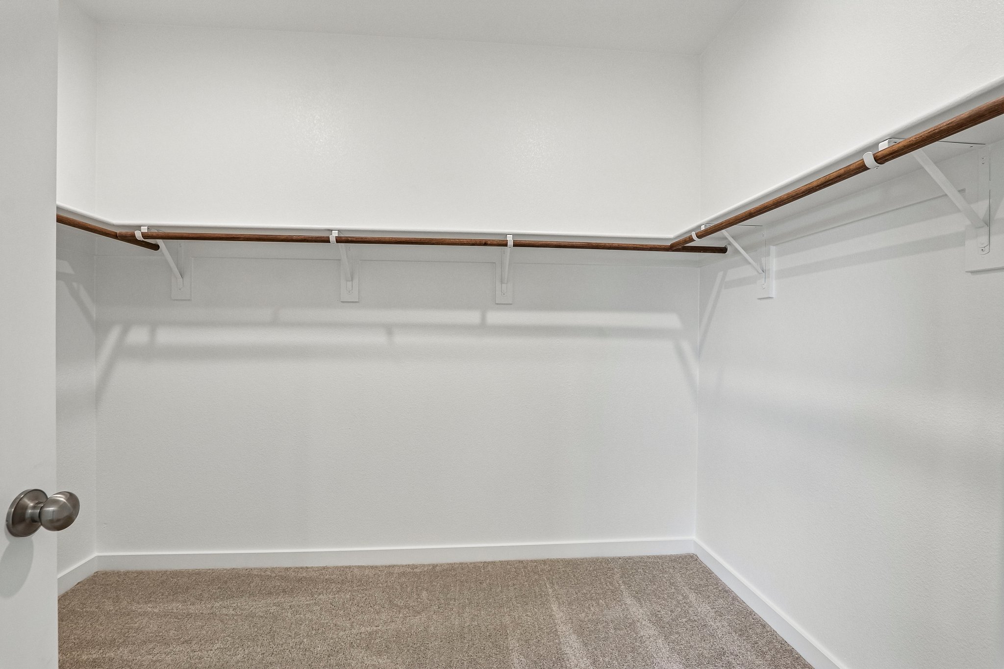 A white wall with a metal bar.