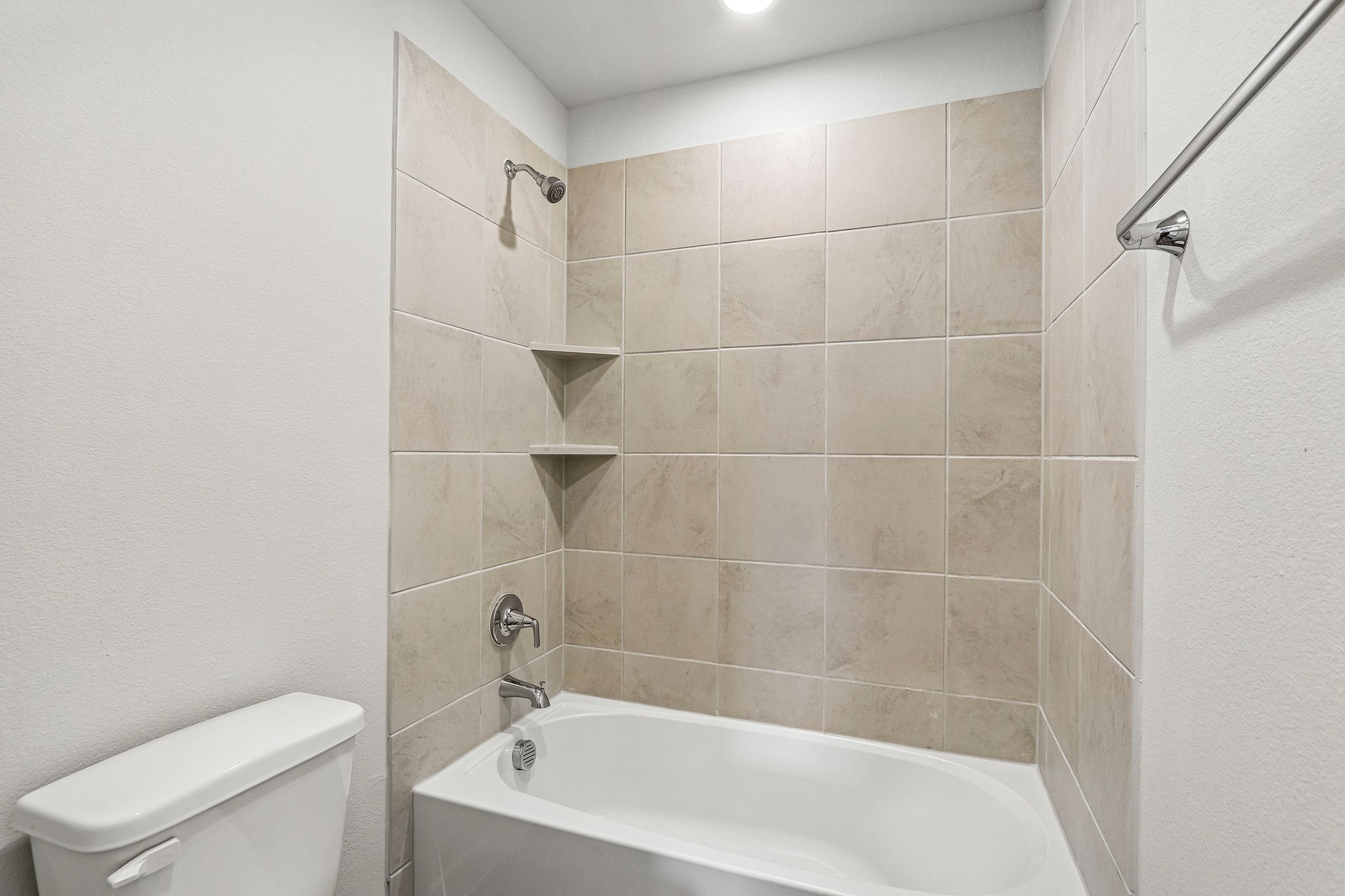 A bathroom with a bathtub and toilet.