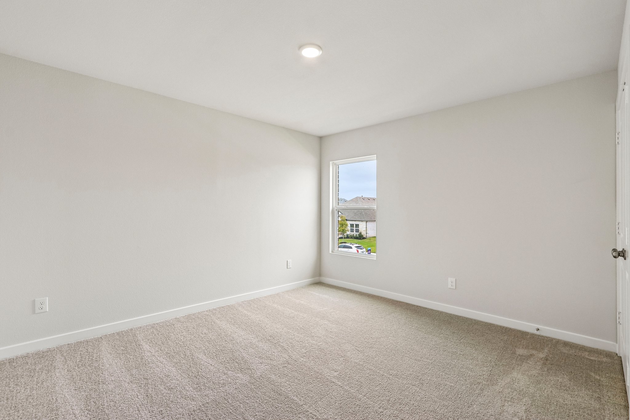 A room with a window and carpet.