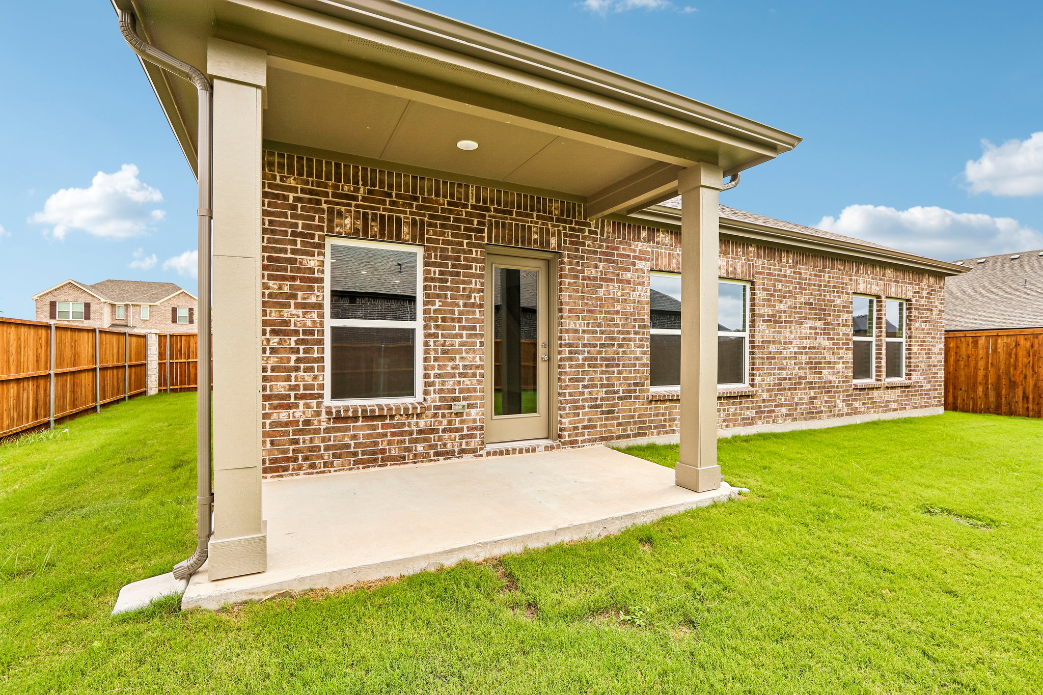 A brick house with a front yard.