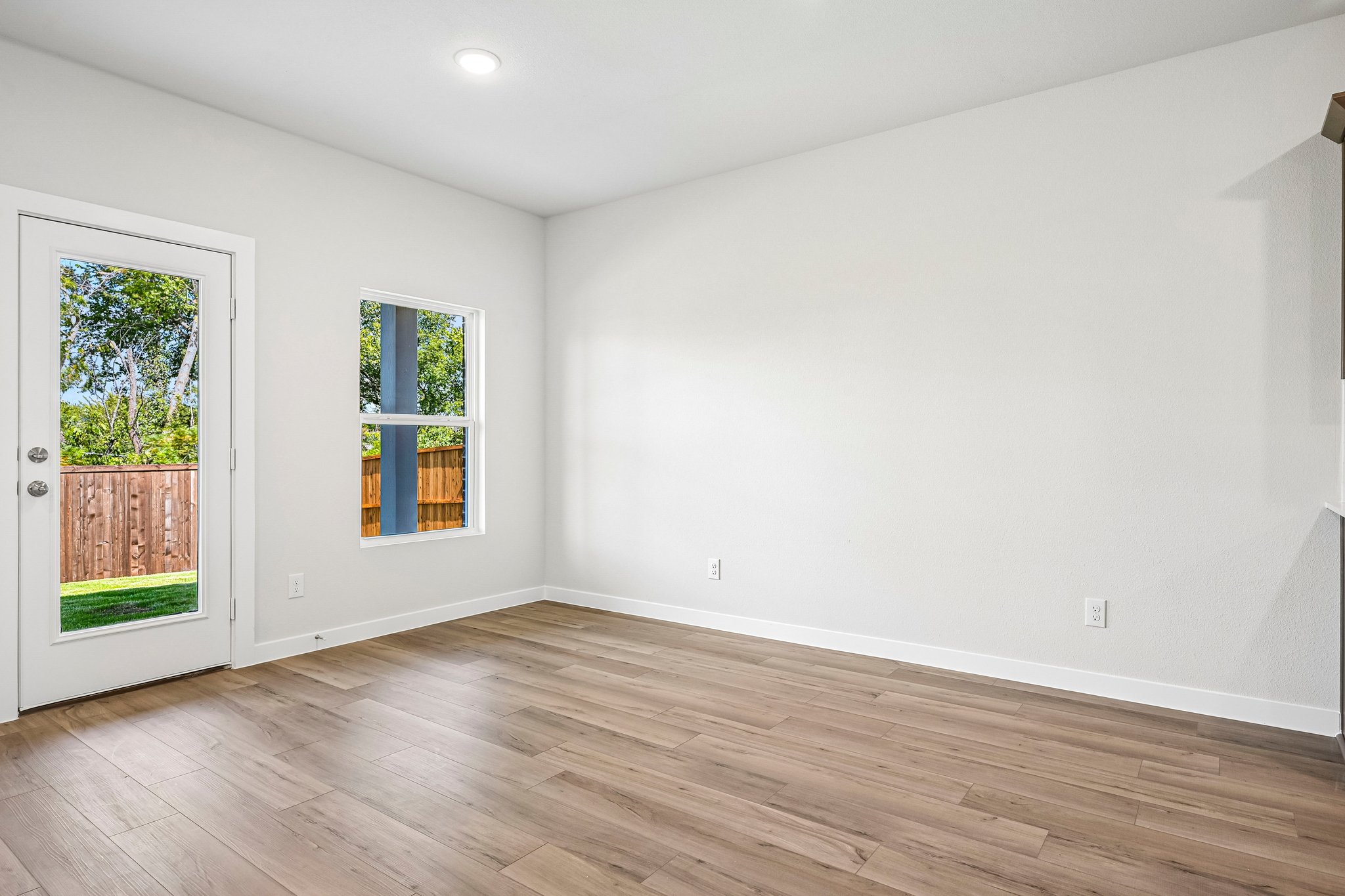 A room with a wood floor and windows.