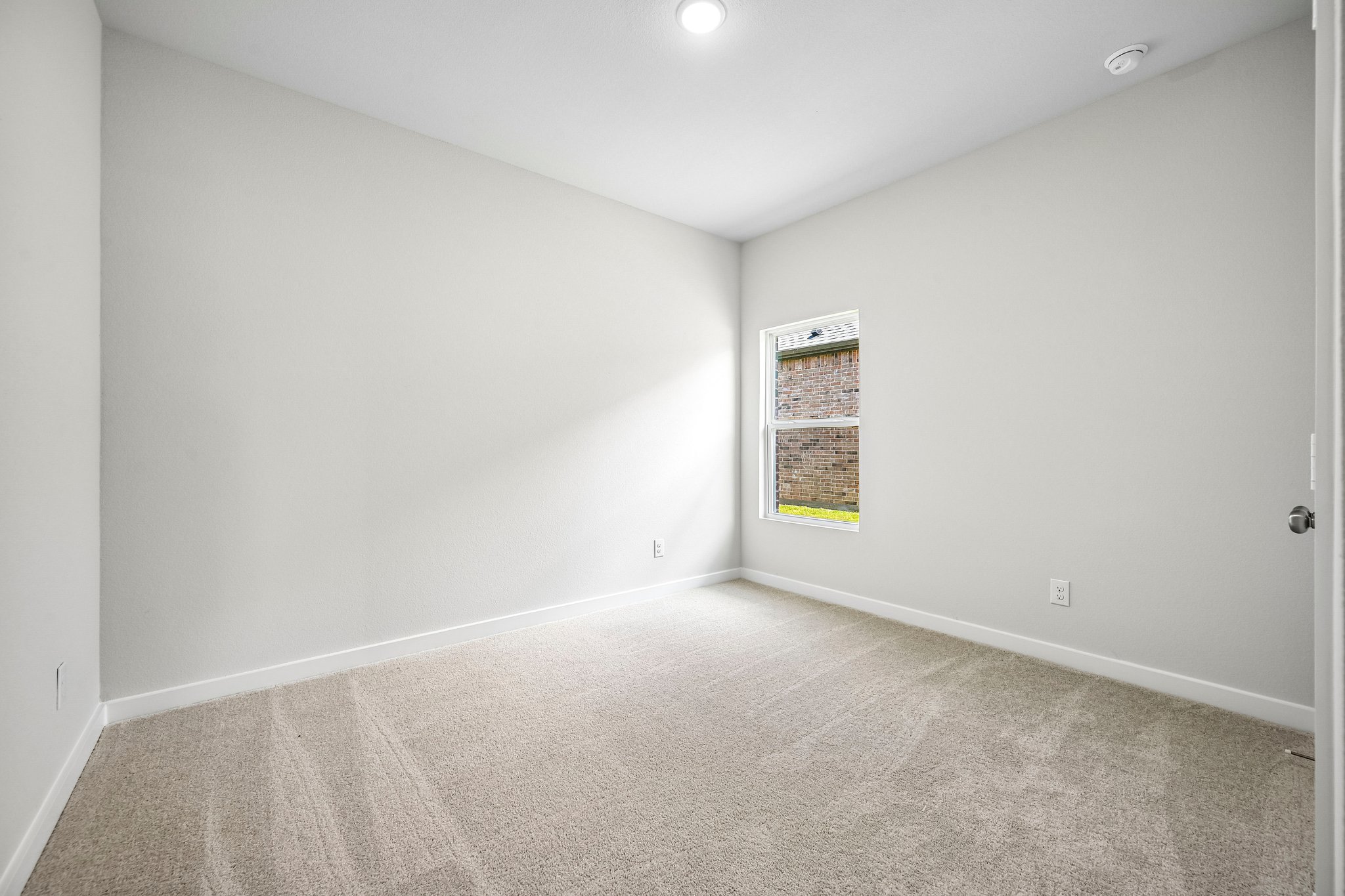 A room with a carpet and a window.