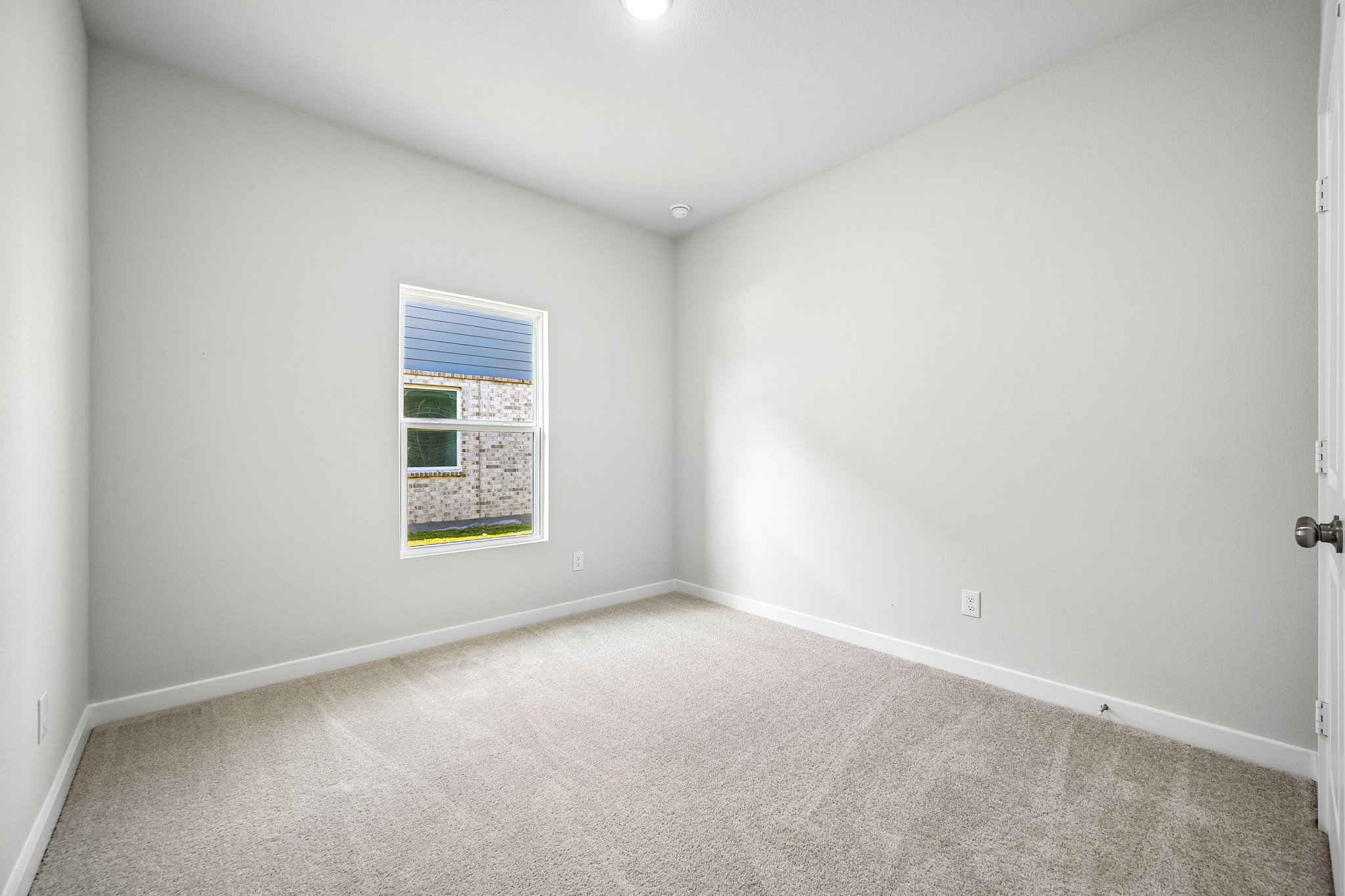 A room with a carpet and a window.