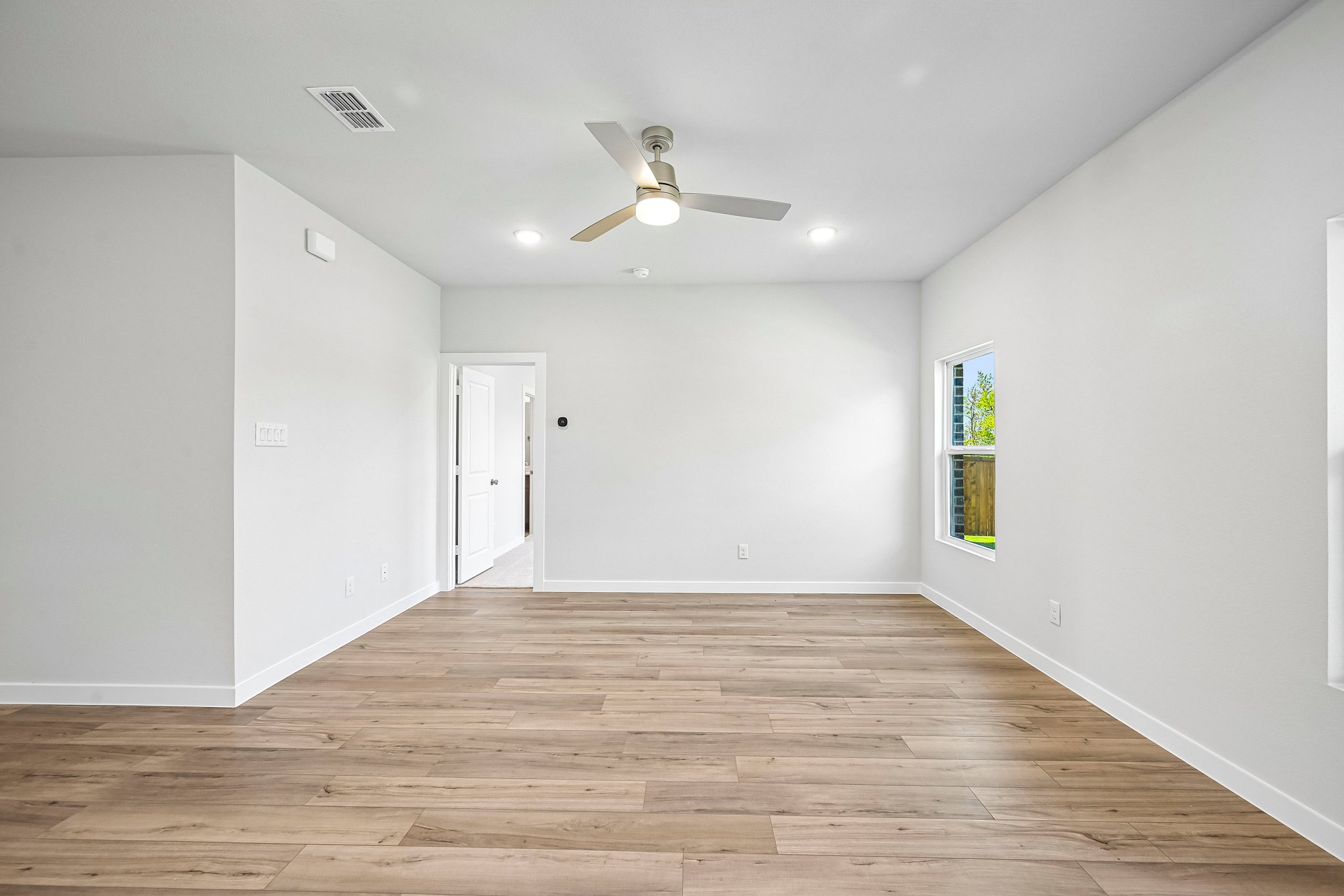 A room with a wood floor and a ceiling fan.