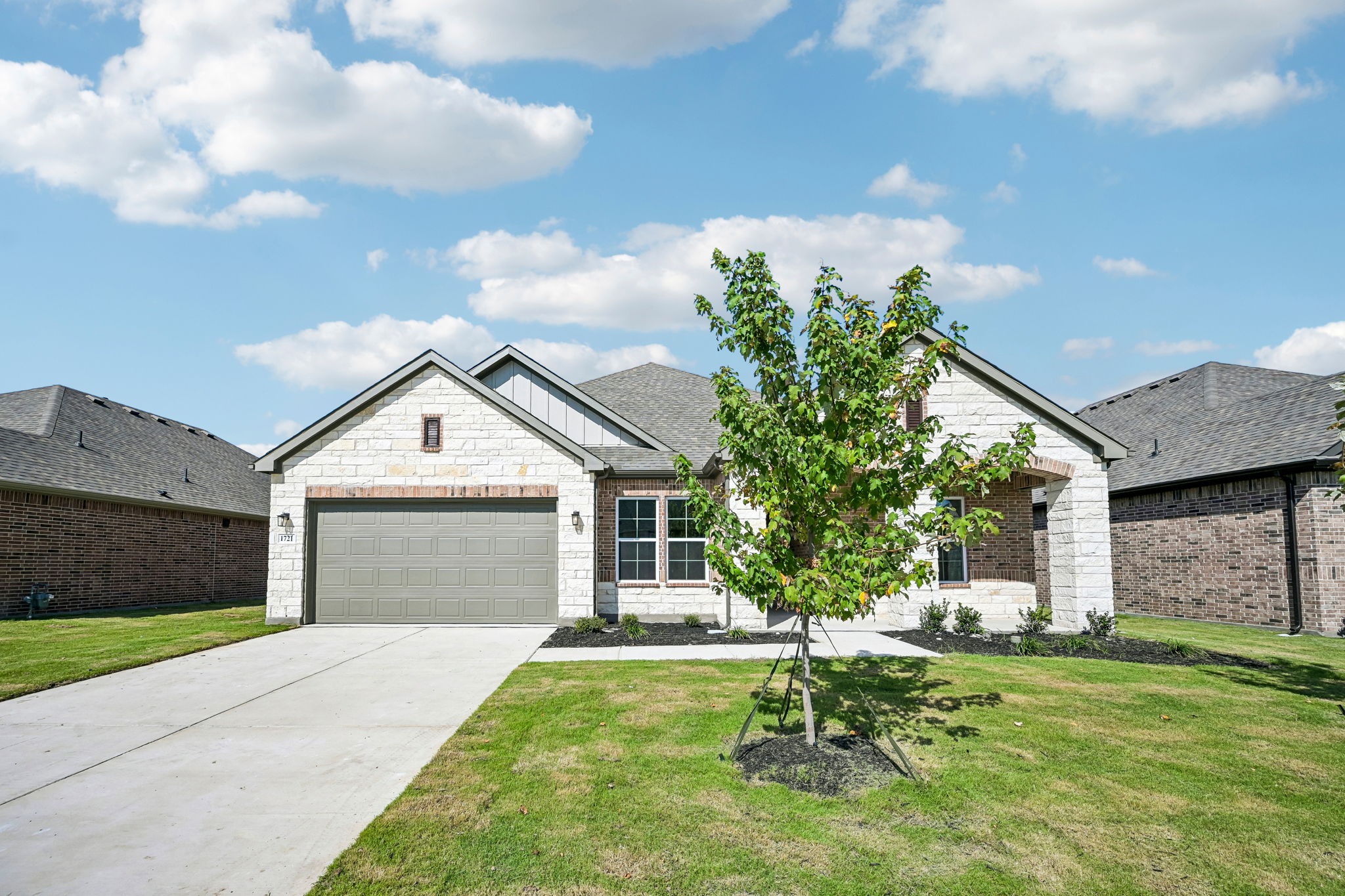 A house with a tree in the front yard.