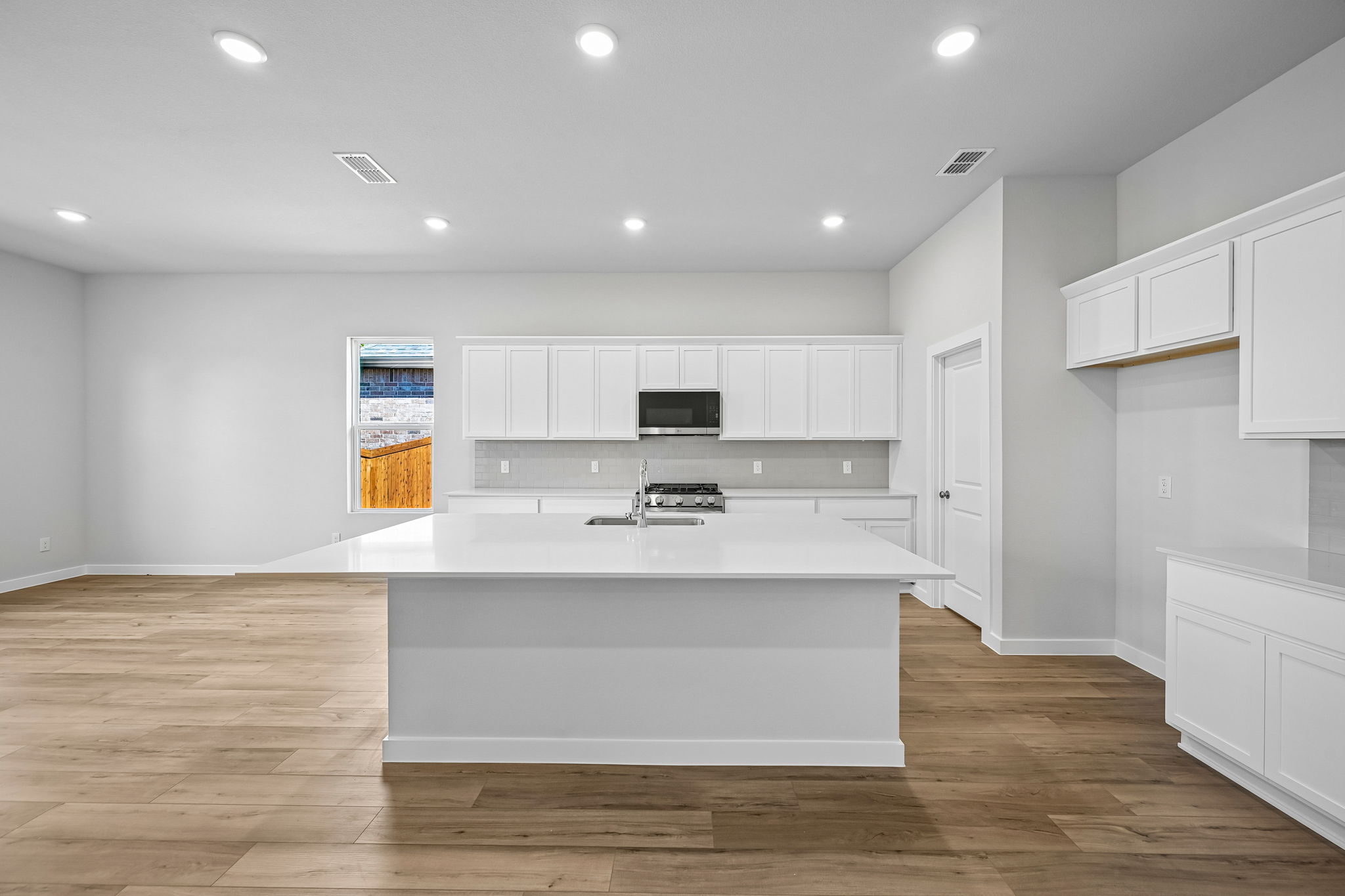 A kitchen with white cabinets.