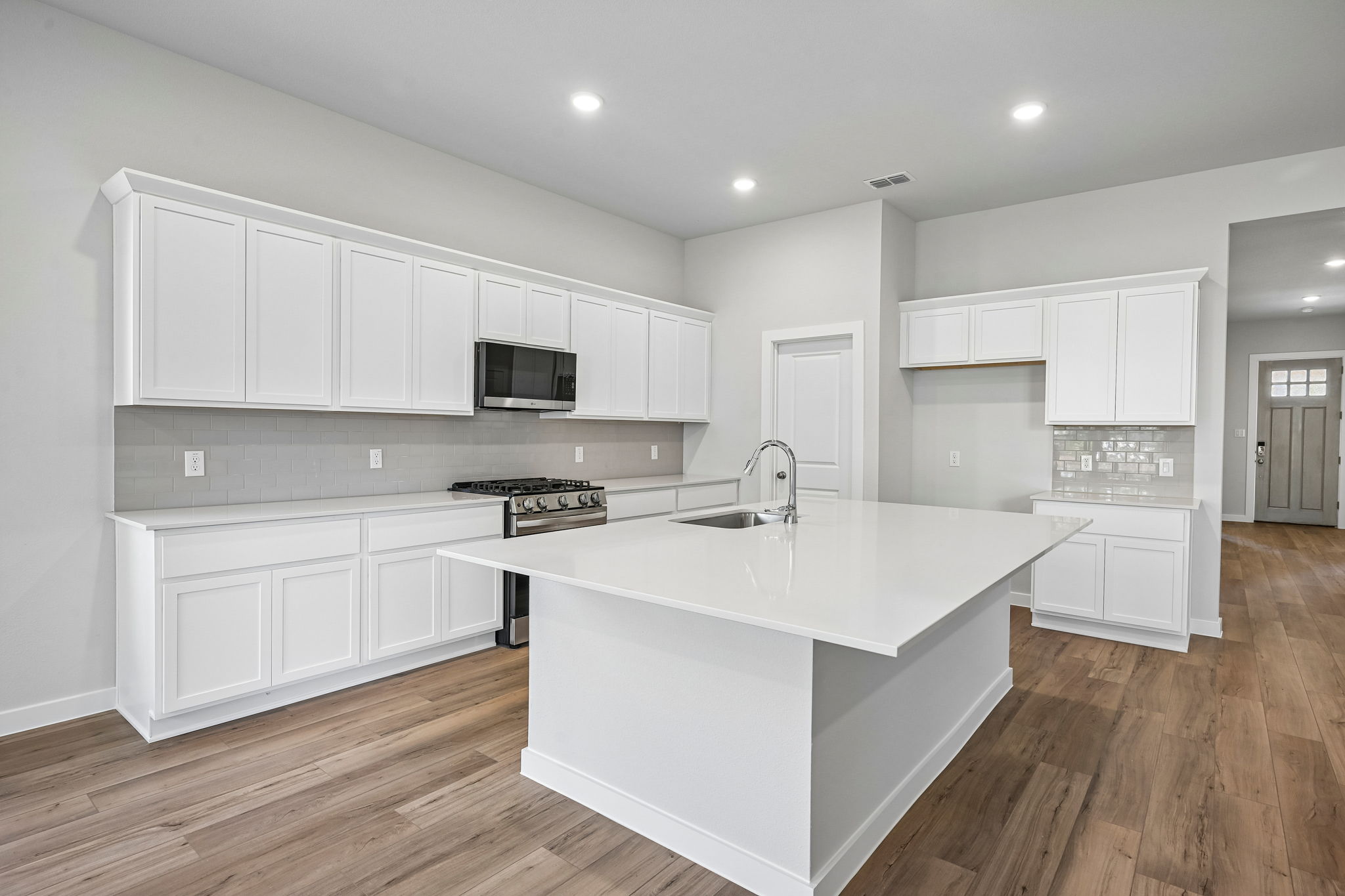 A kitchen with white cabinets.