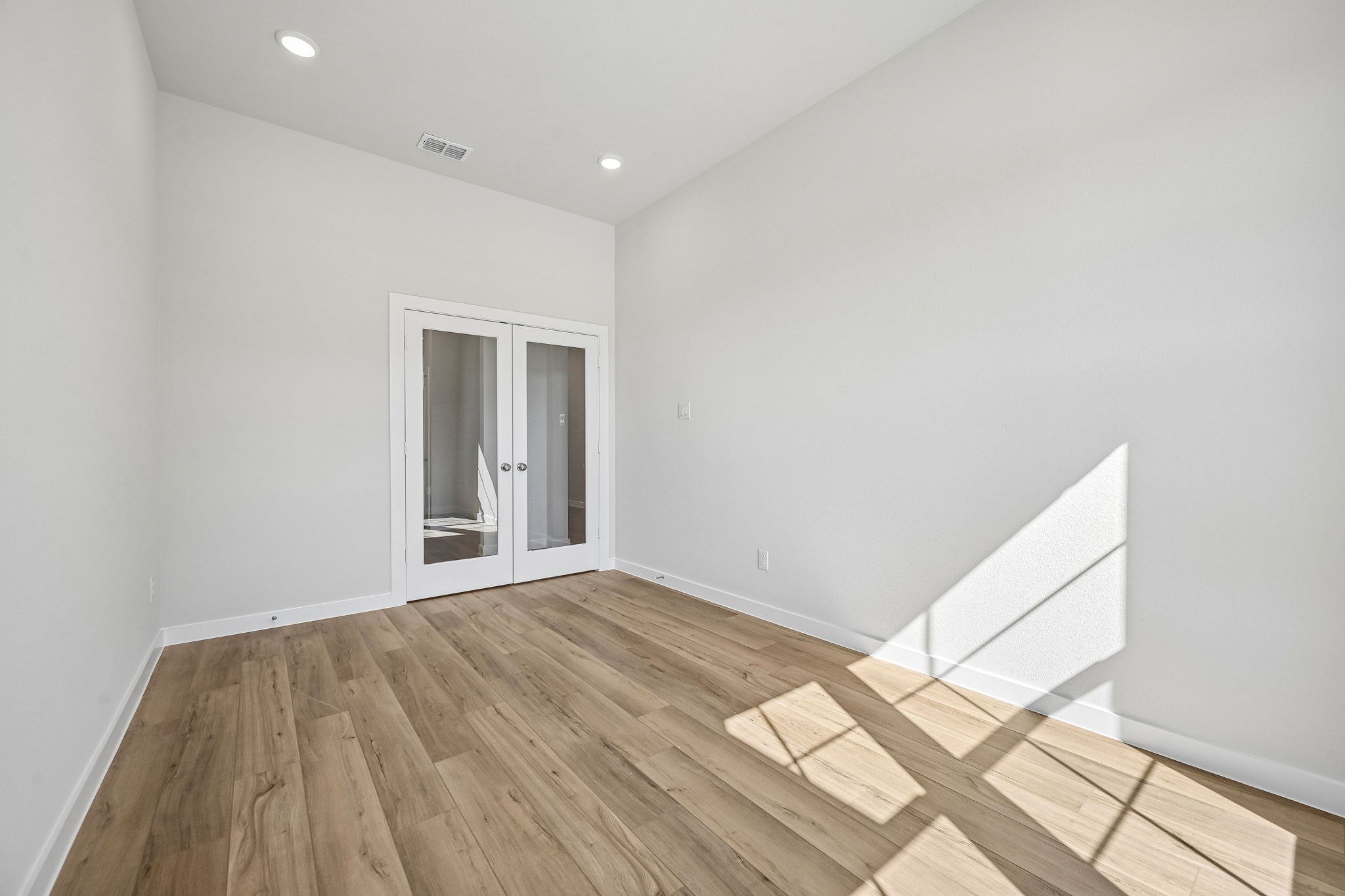 A room with a wood floor and white walls.