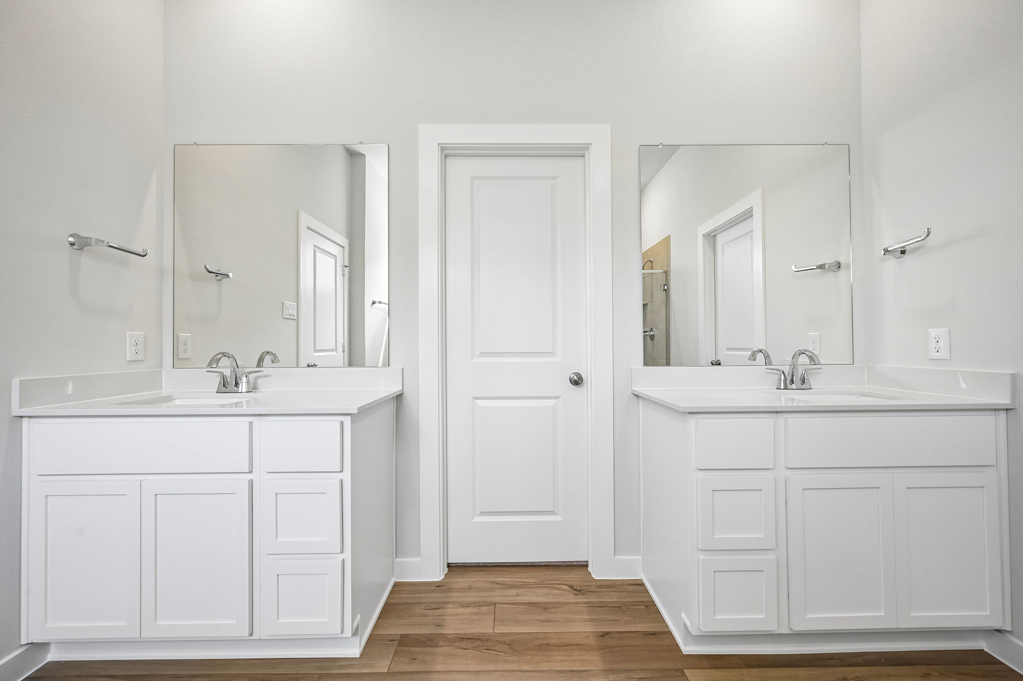 A bathroom with white cabinets.