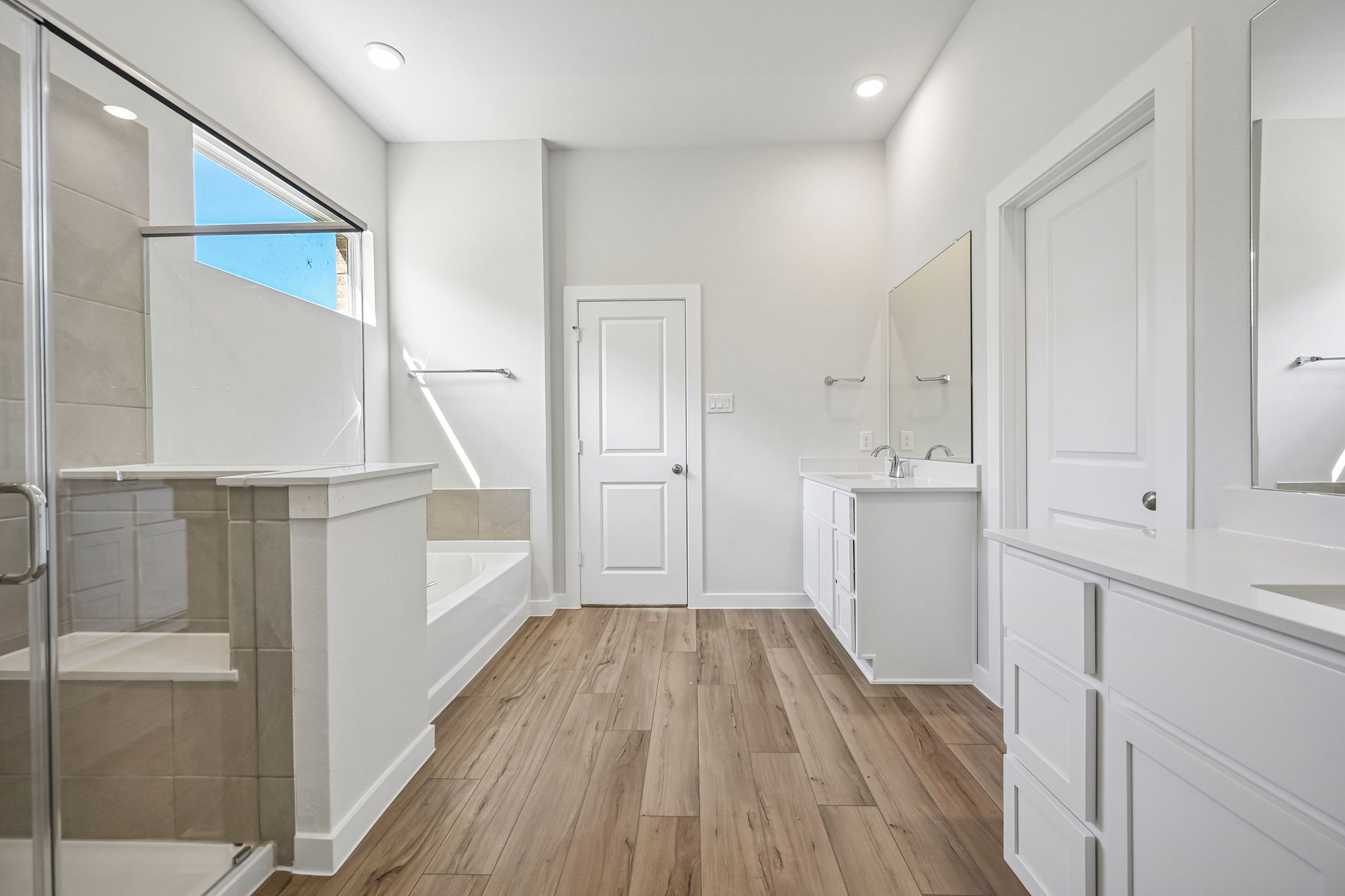 A bathroom with white cabinets.