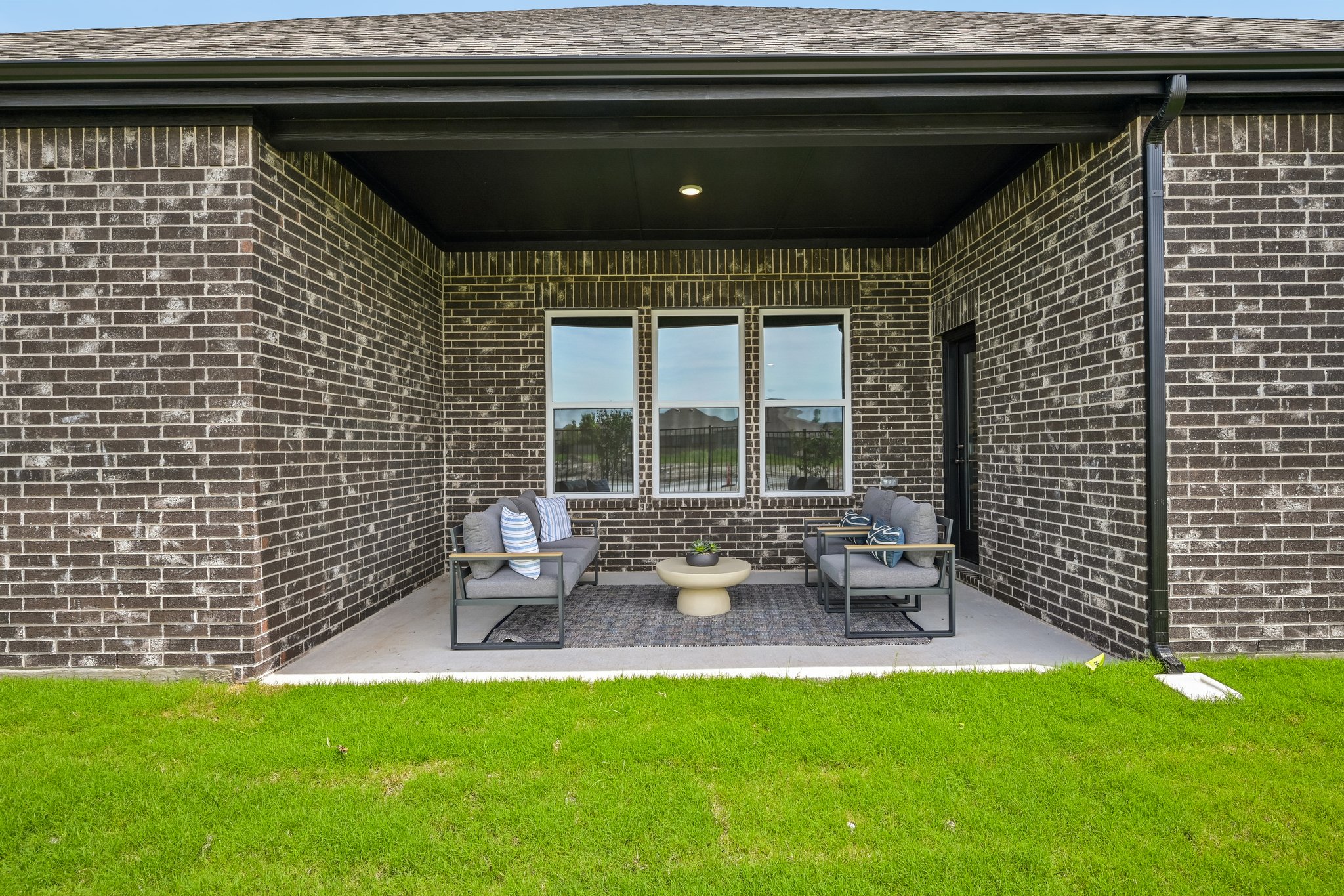 A brick building with a bench and a potted plant in the front.