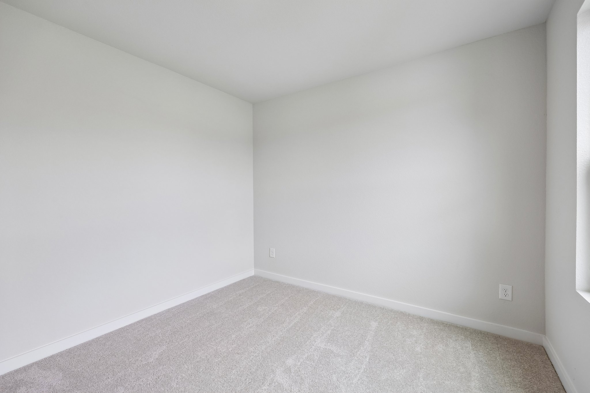 A white room with a grey carpet.