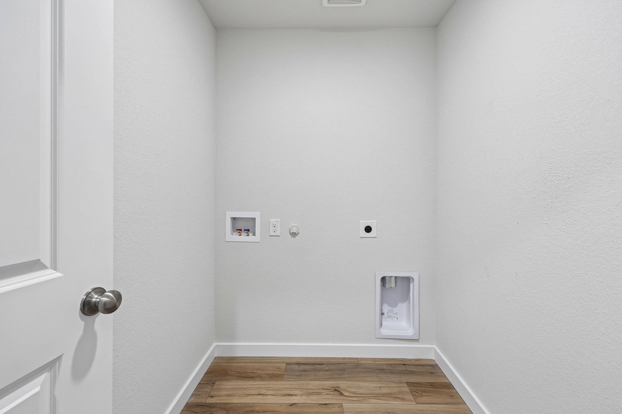 A white room with a wood floor.