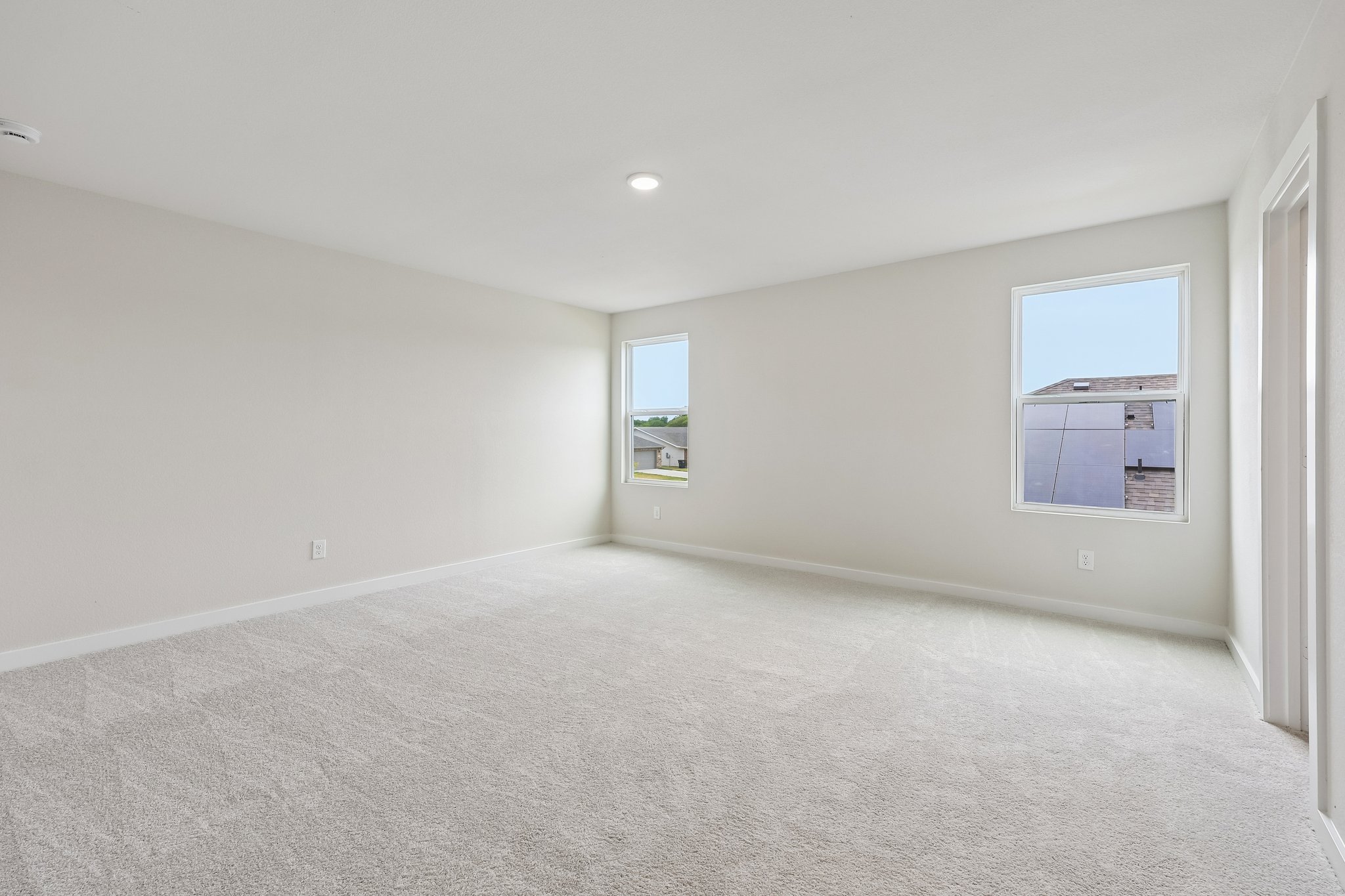 A room with a carpet and a window.