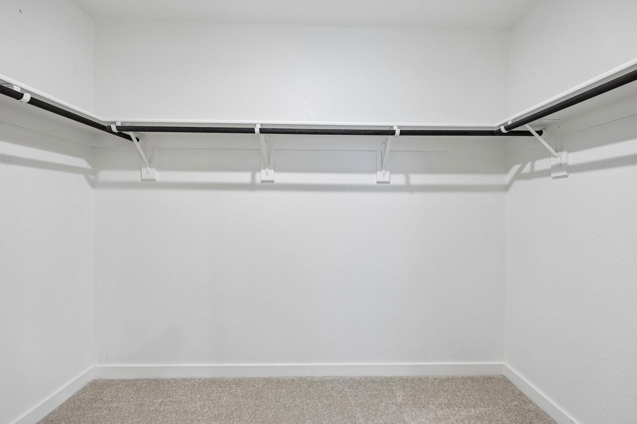 A white wall with a metal bar.