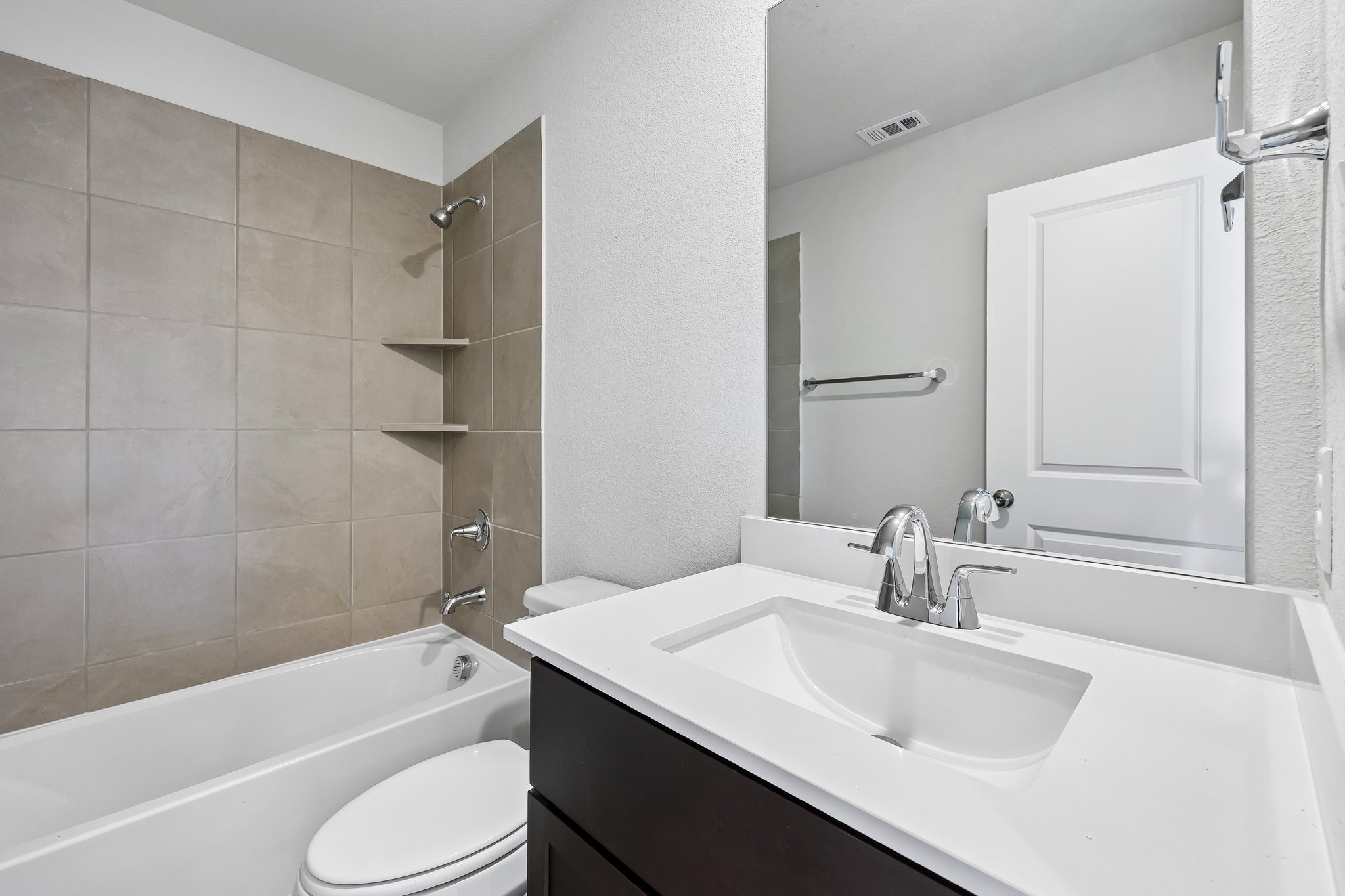 A bathroom with a tub sink and toilet.